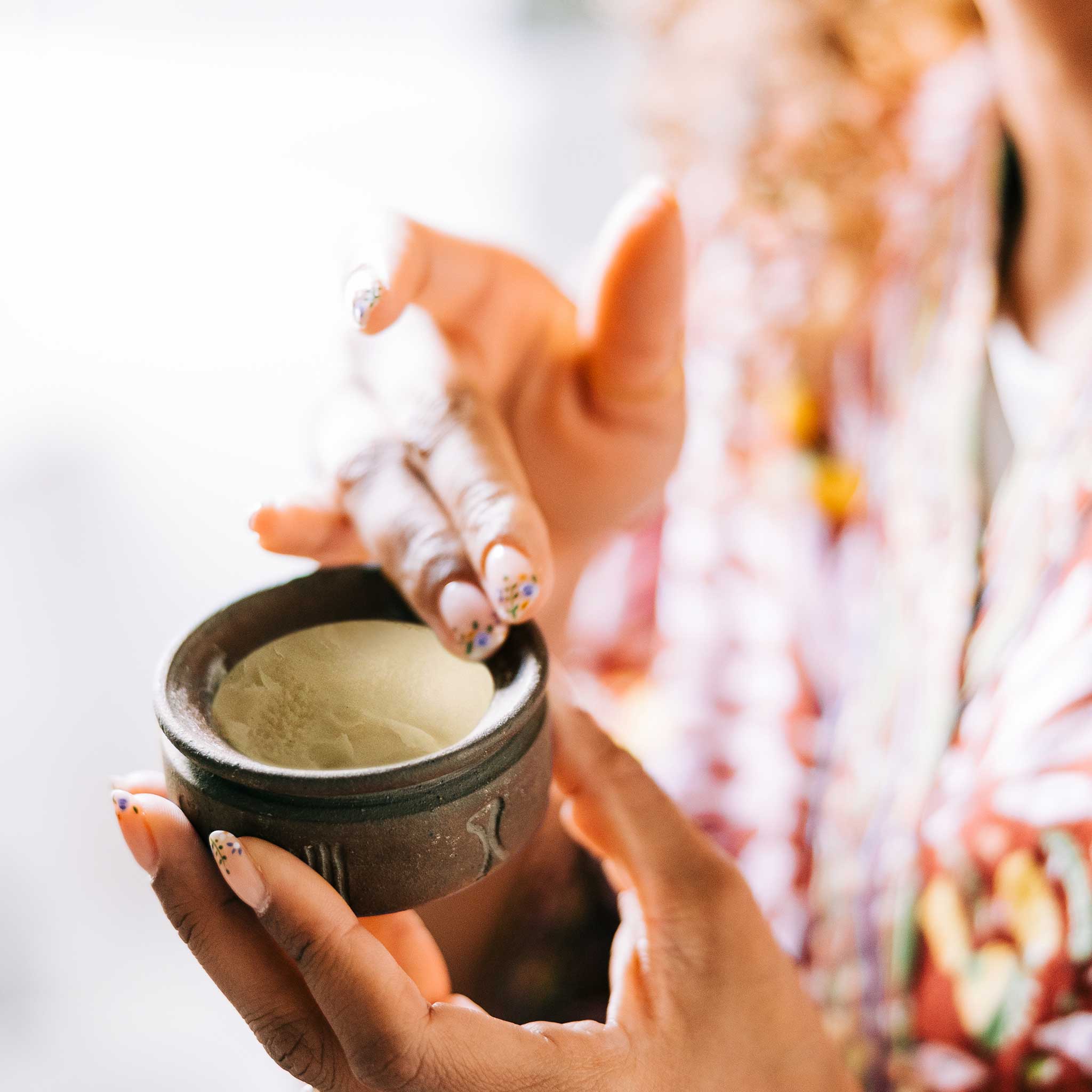 Artisan applying shea butter cream to dry skin for hydration