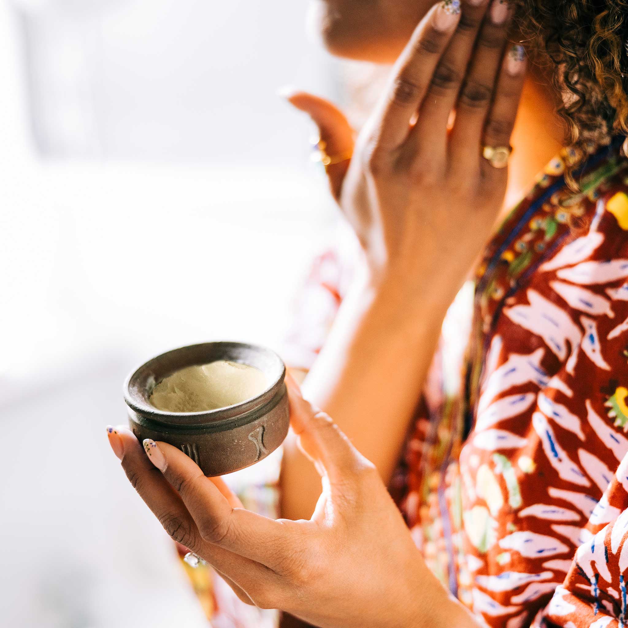 Artisan applying shea butter cream to dry skin for hydration