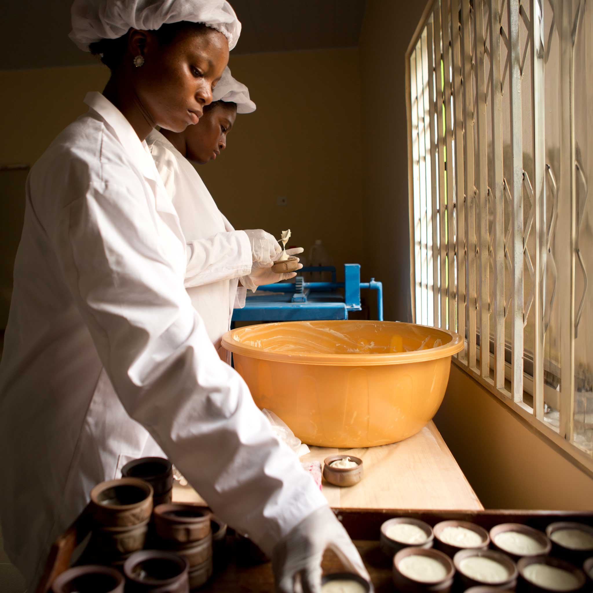 Artisan applying shea butter cream to dry skin for hydration