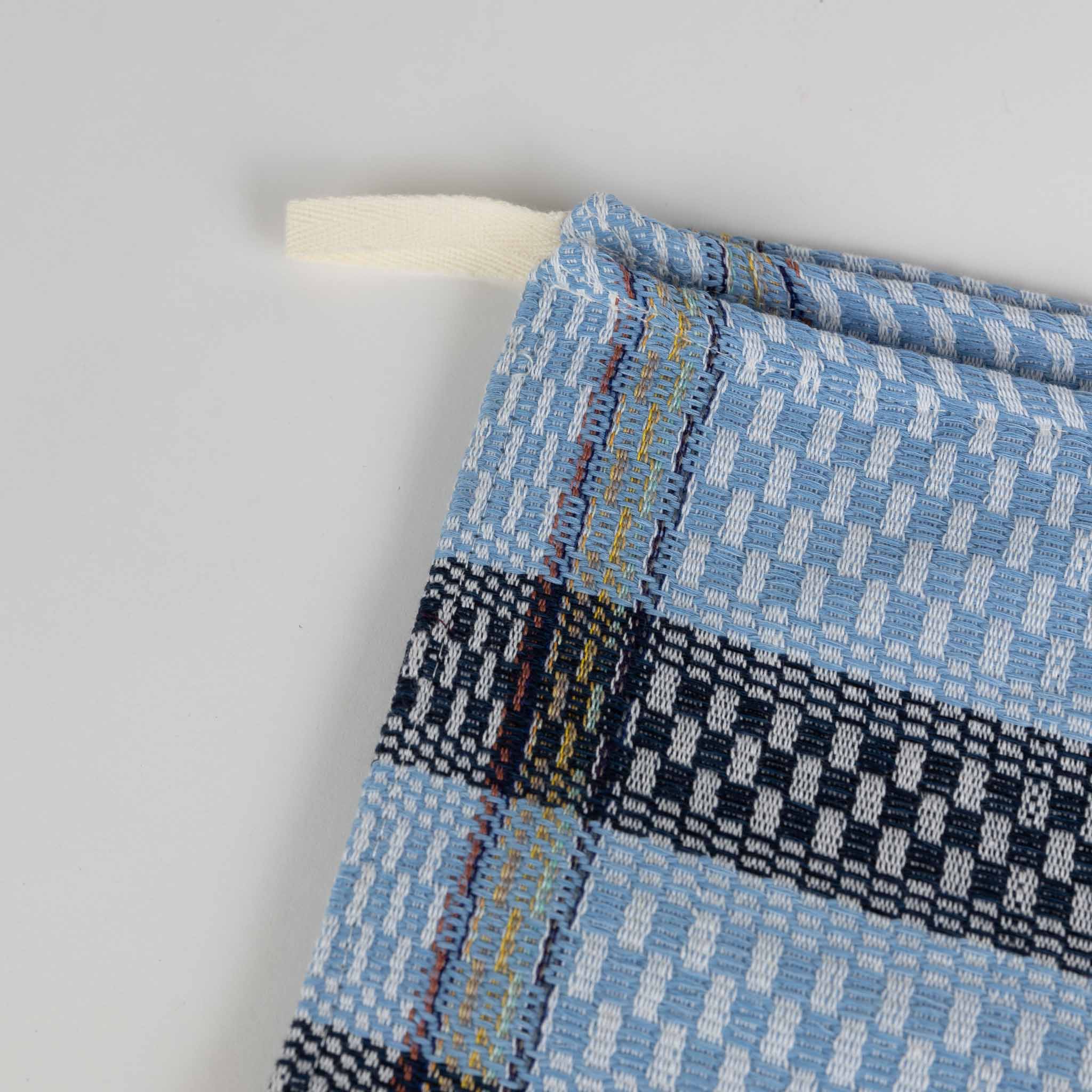Blue striped tea towel draped over the shoulder, showcasing its quick drying design.