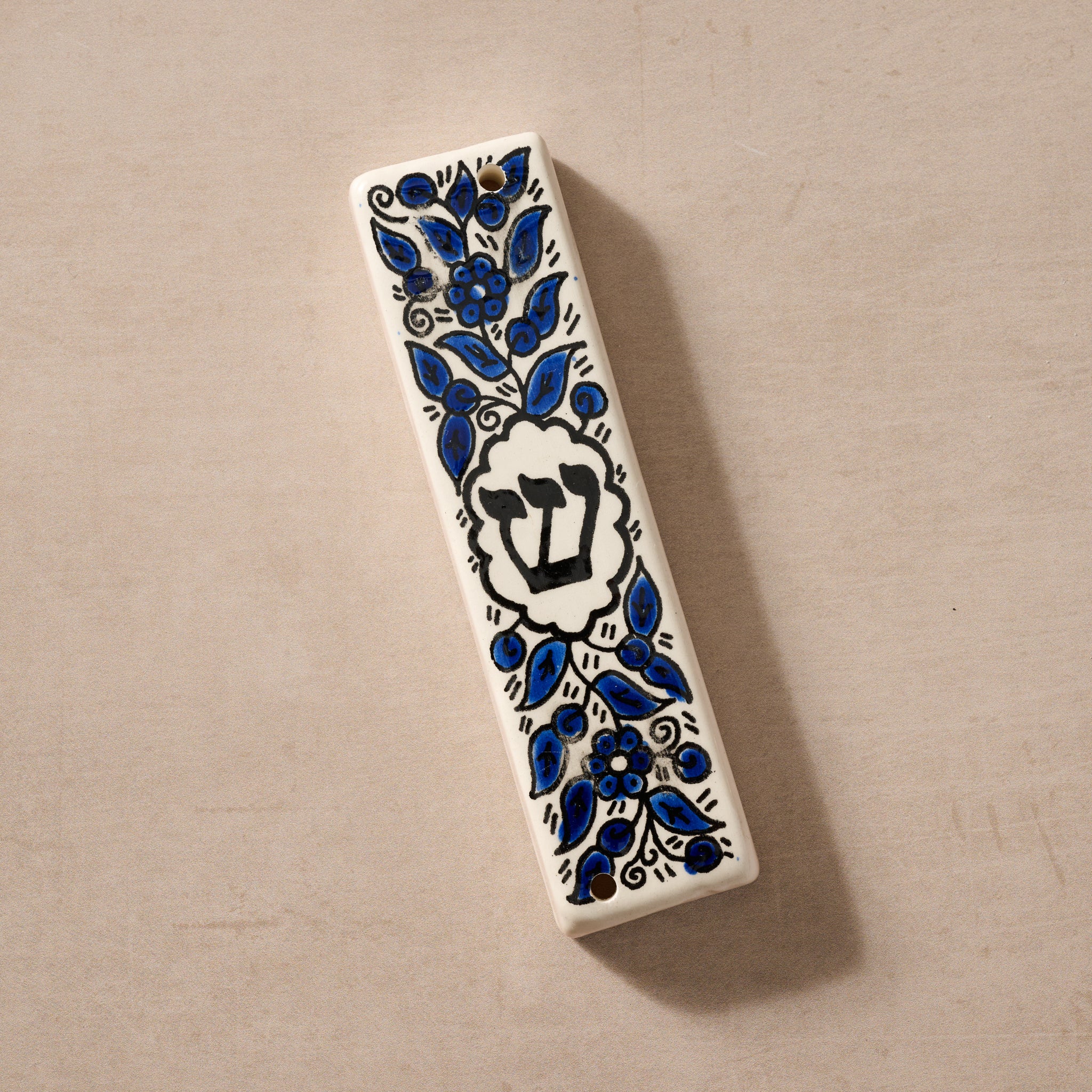 Close-up of hand-painted flowering mezuzah on doorpost