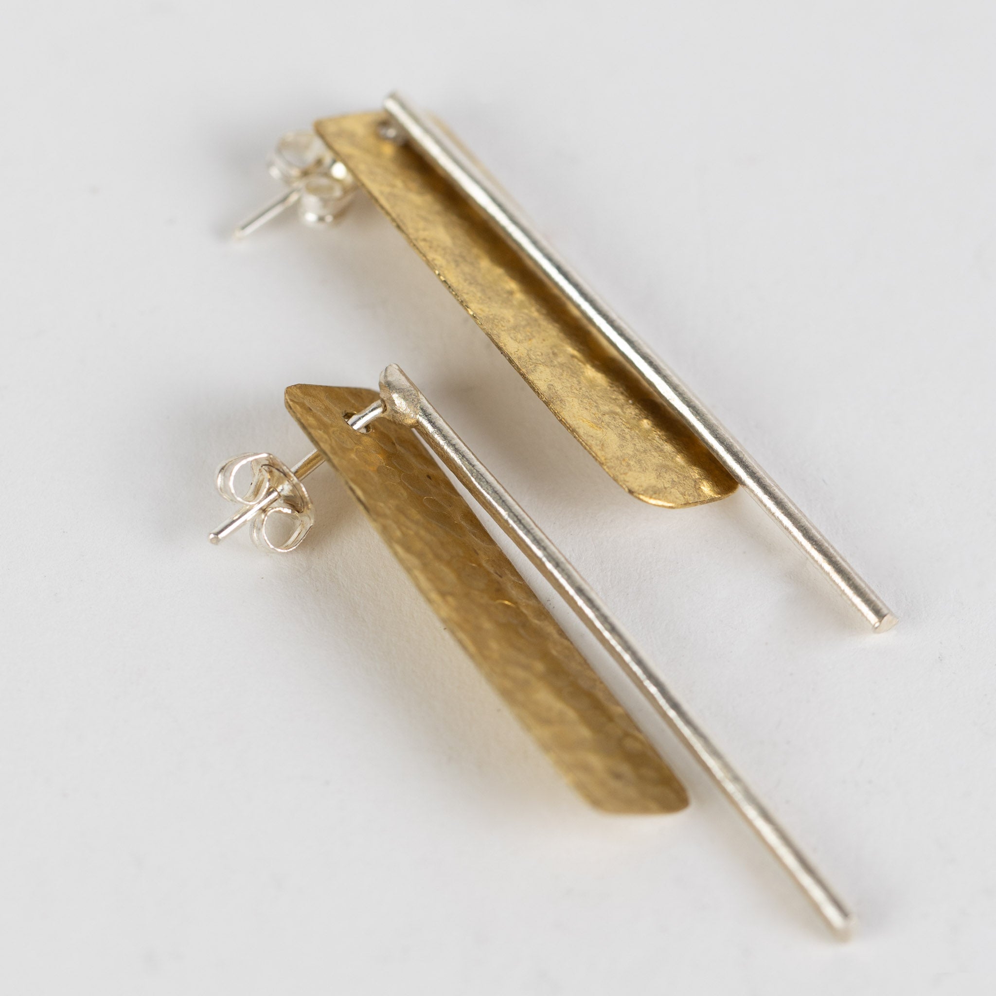 Close-up of the handcrafted brass earrings displaying the intricate hammered texture.
