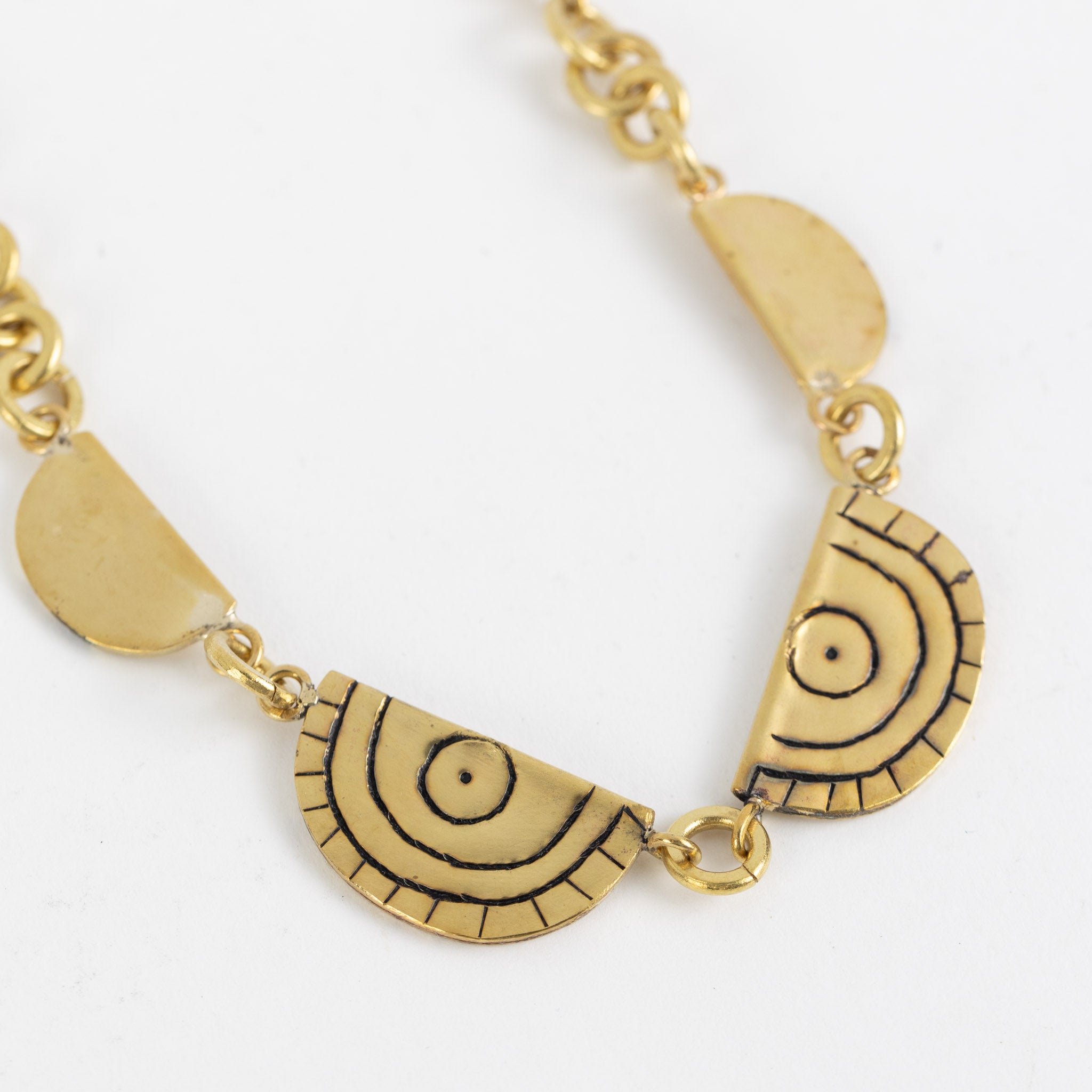Handcrafted brass statement necklace from Kenya showcasing etching details