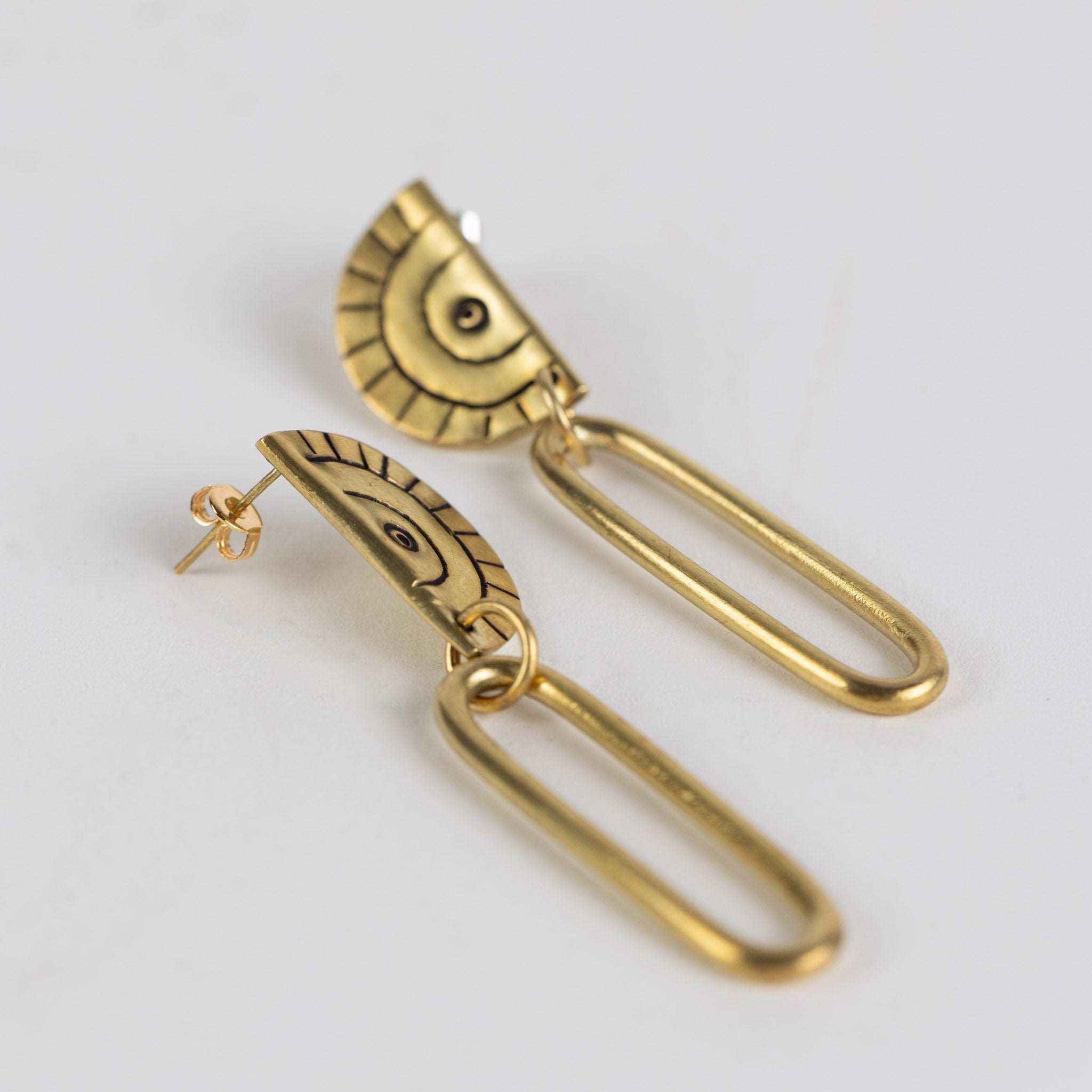 Close-up of handcrafted brass earrings with intricate etching, showcasing the Miduara circle design.