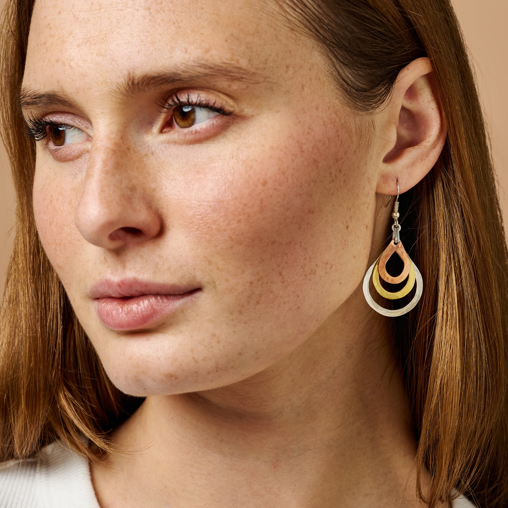Close-up of Trinity Teardrop Hoop Earrings showcasing copper, brass, and silver details.