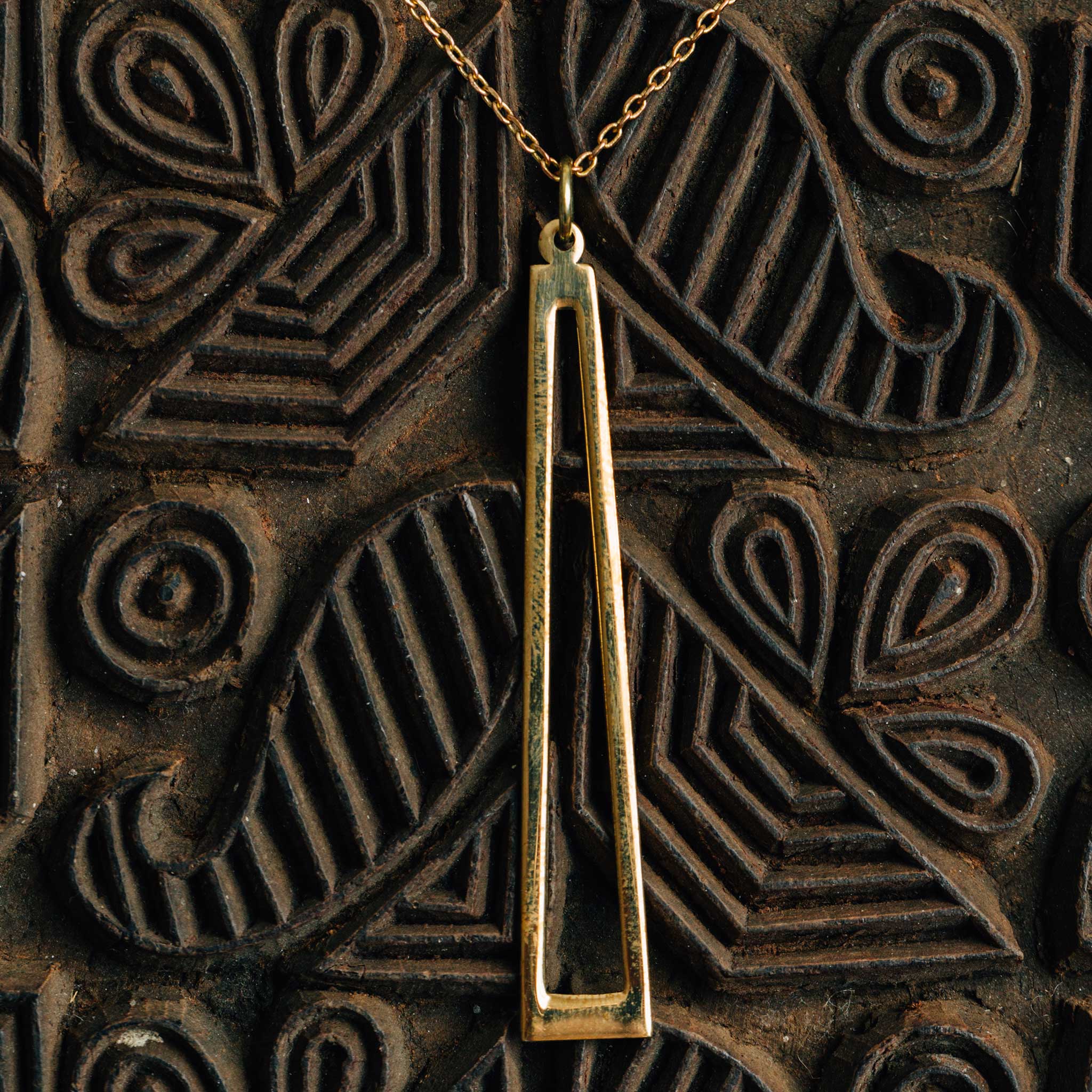 Artisan crafting the recycled brass pendant in their workshop