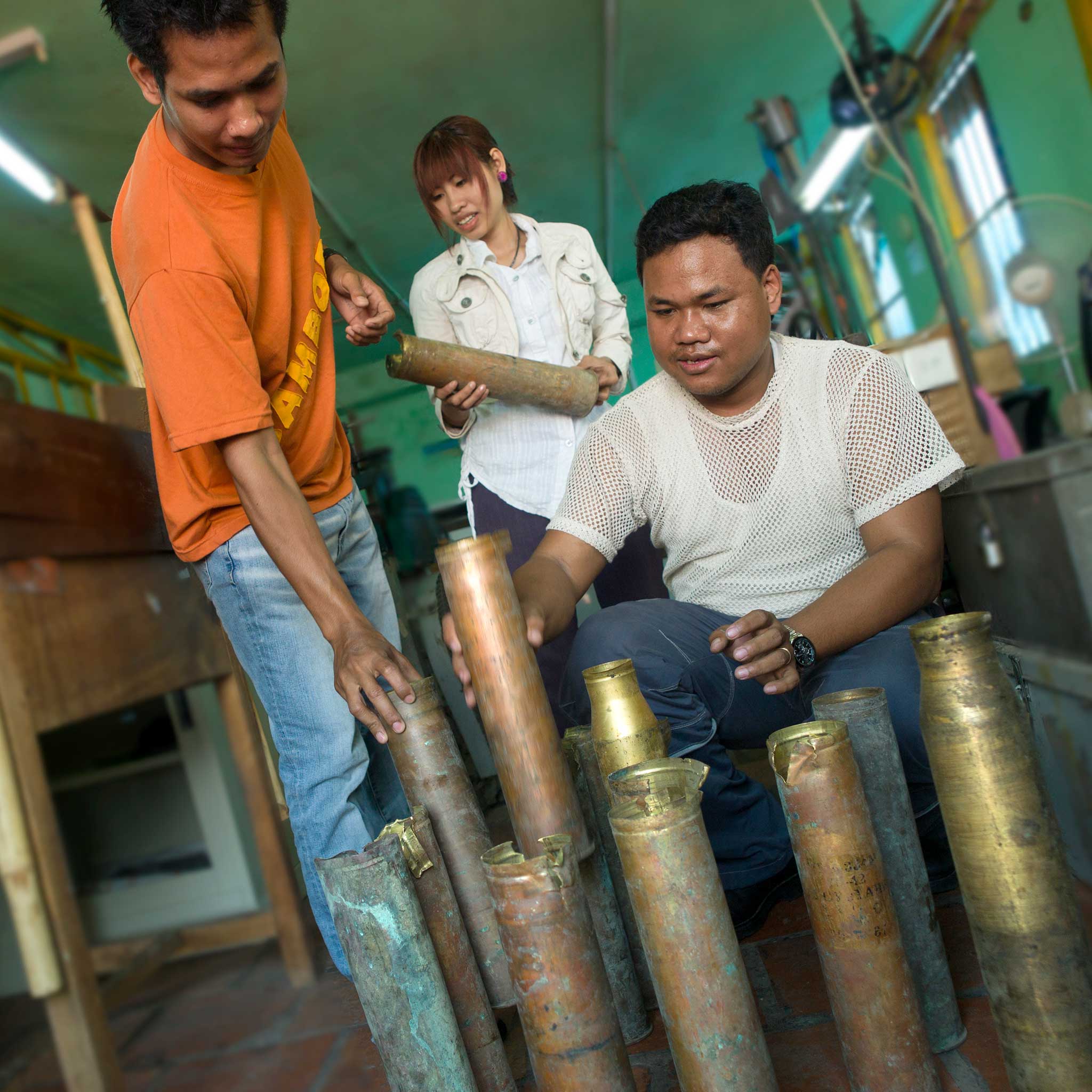 Artisan in Cambodia melting brass bomb casings into jewelry, highlighting sustainable craftsmanship