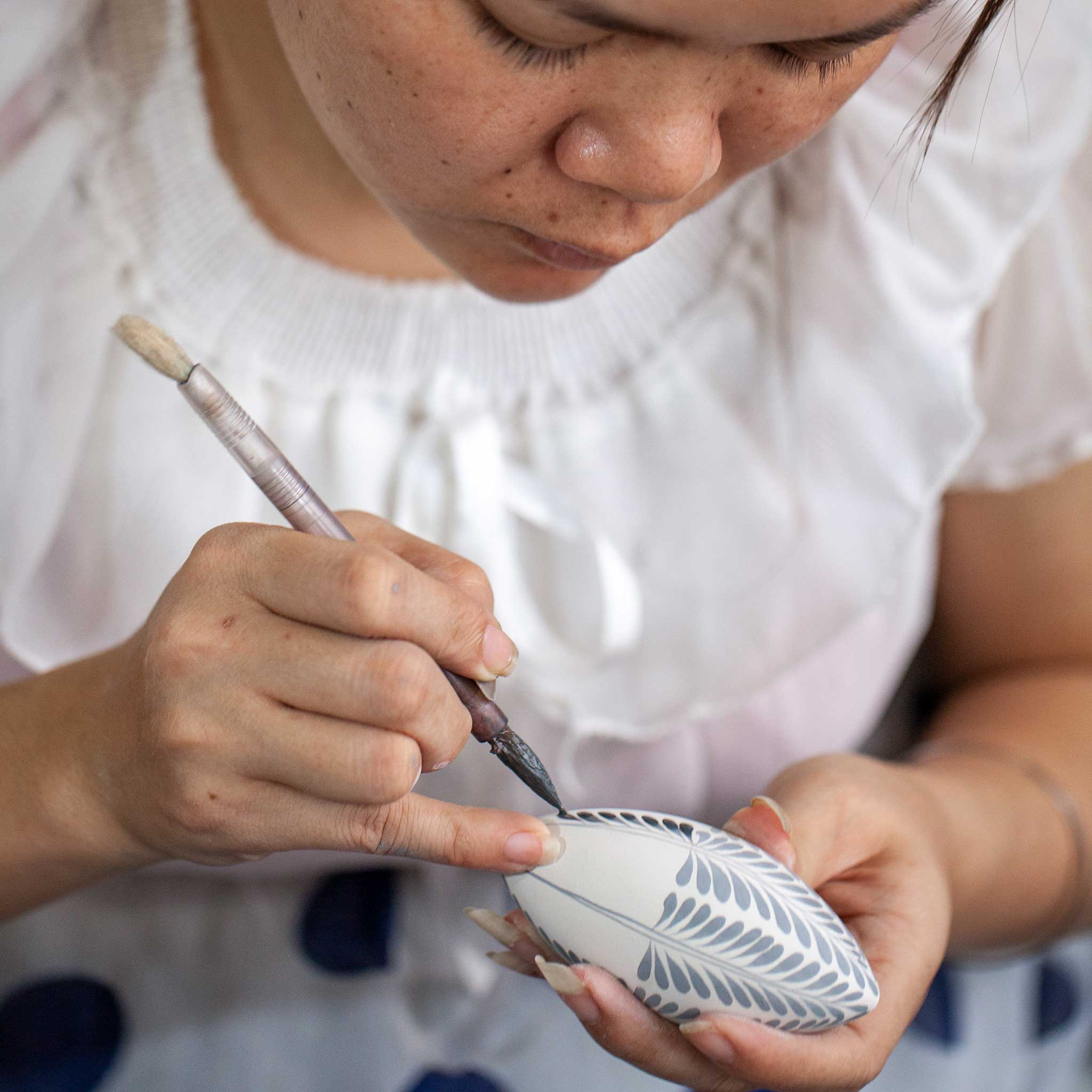 Close-up of rain-themed hand-painted Vietnamese pottery mug showing detailed artwork