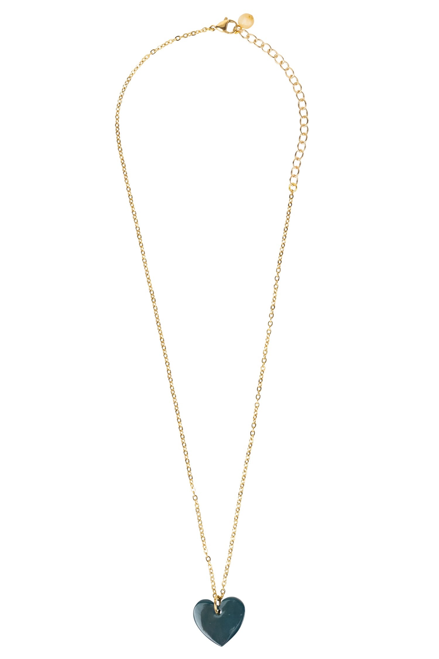 Close-up of the artisan heart necklace with red pendant on gold chain, highlighting craftsmanship