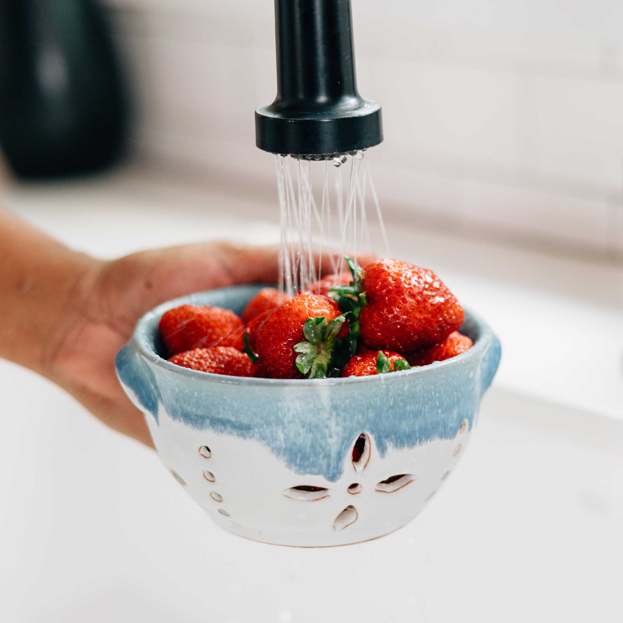 Close-up of blue and white ceramic bowl showing built-in strainer feature
