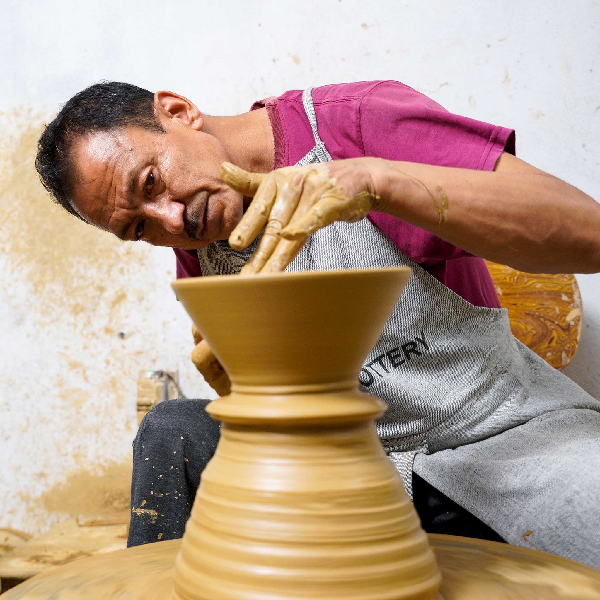 Artisan creating a handmade salad bowl in pottery workshop