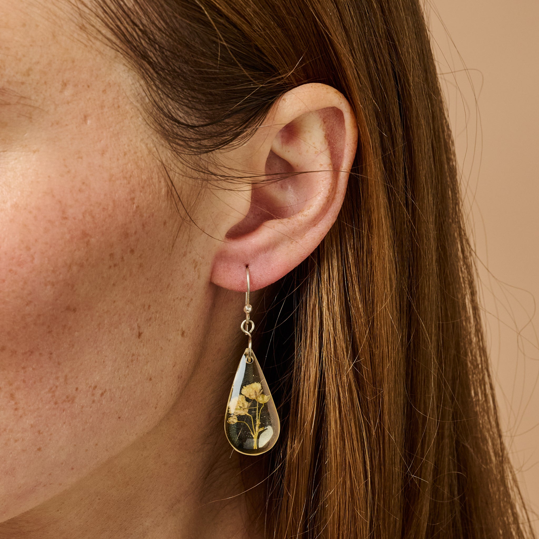 Ethereal Bloom Resin Flower Earrings showcasing vibrant dried flowers from a side angle.