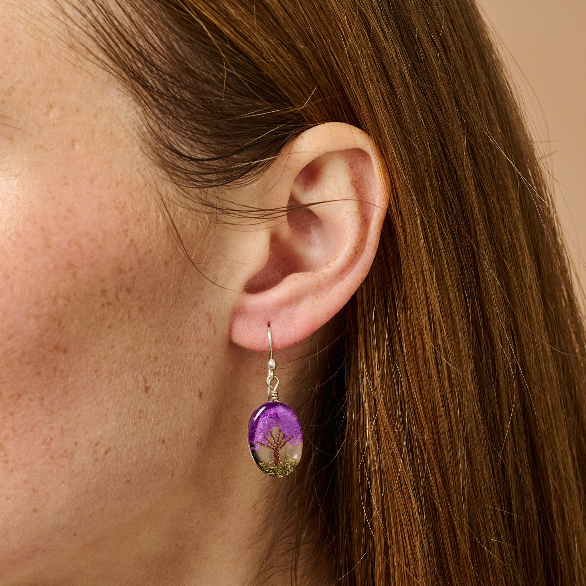 Purple dangling earrings showcasing a tree design made with resin and stone chips, perfect for nature enthusiasts.