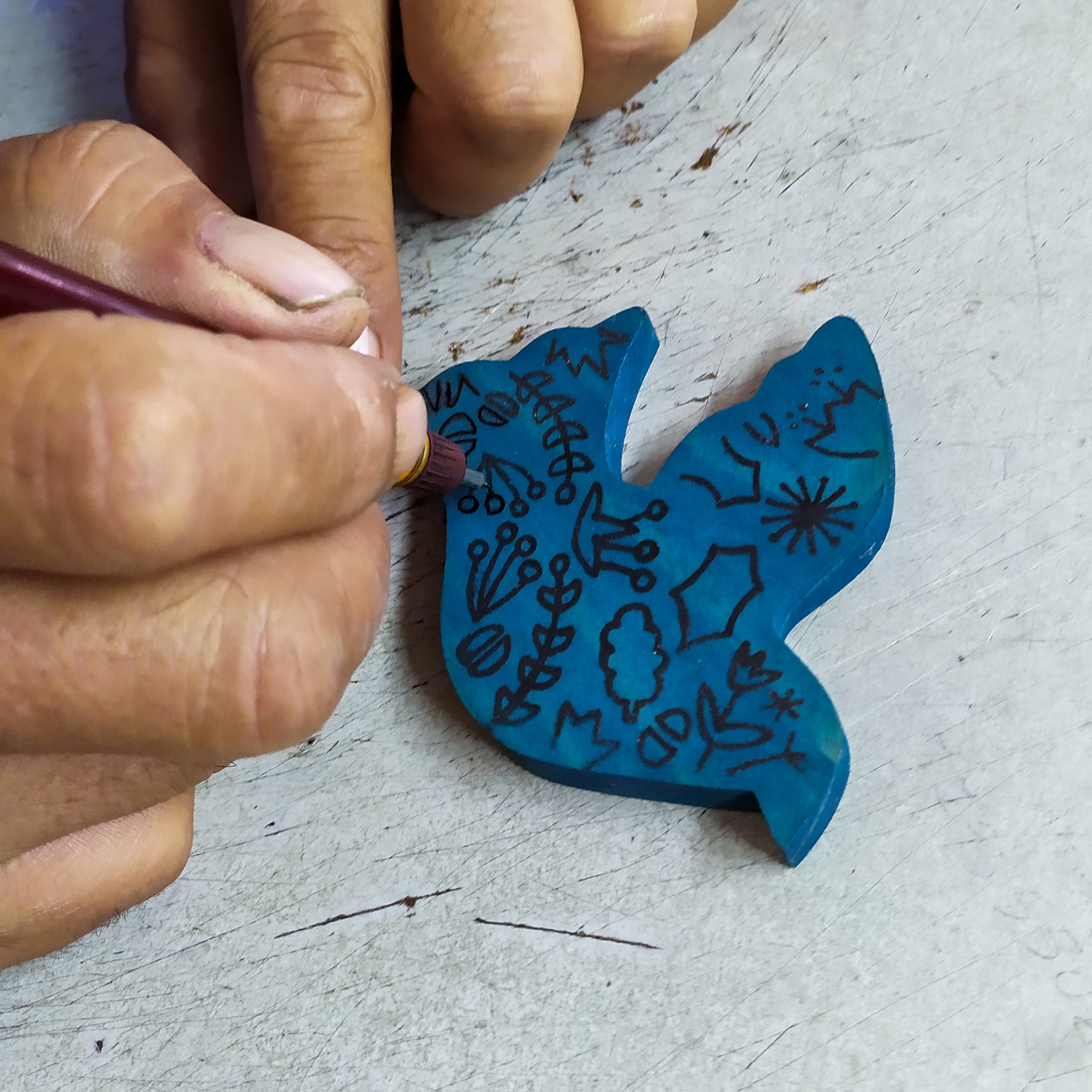 Close-up of the hand-painted floral design on the dove ornament, highlighting artisan craftsmanship.