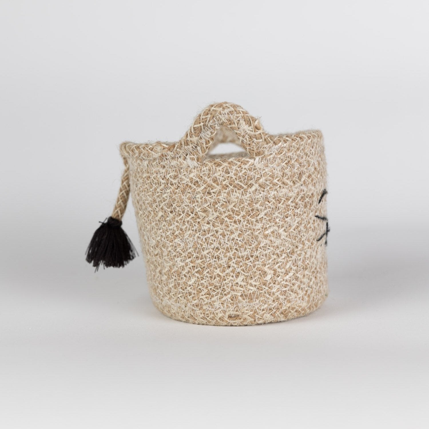 Stylish jute basket with a playful cat face, suitable as a decorative piece or plant holder.