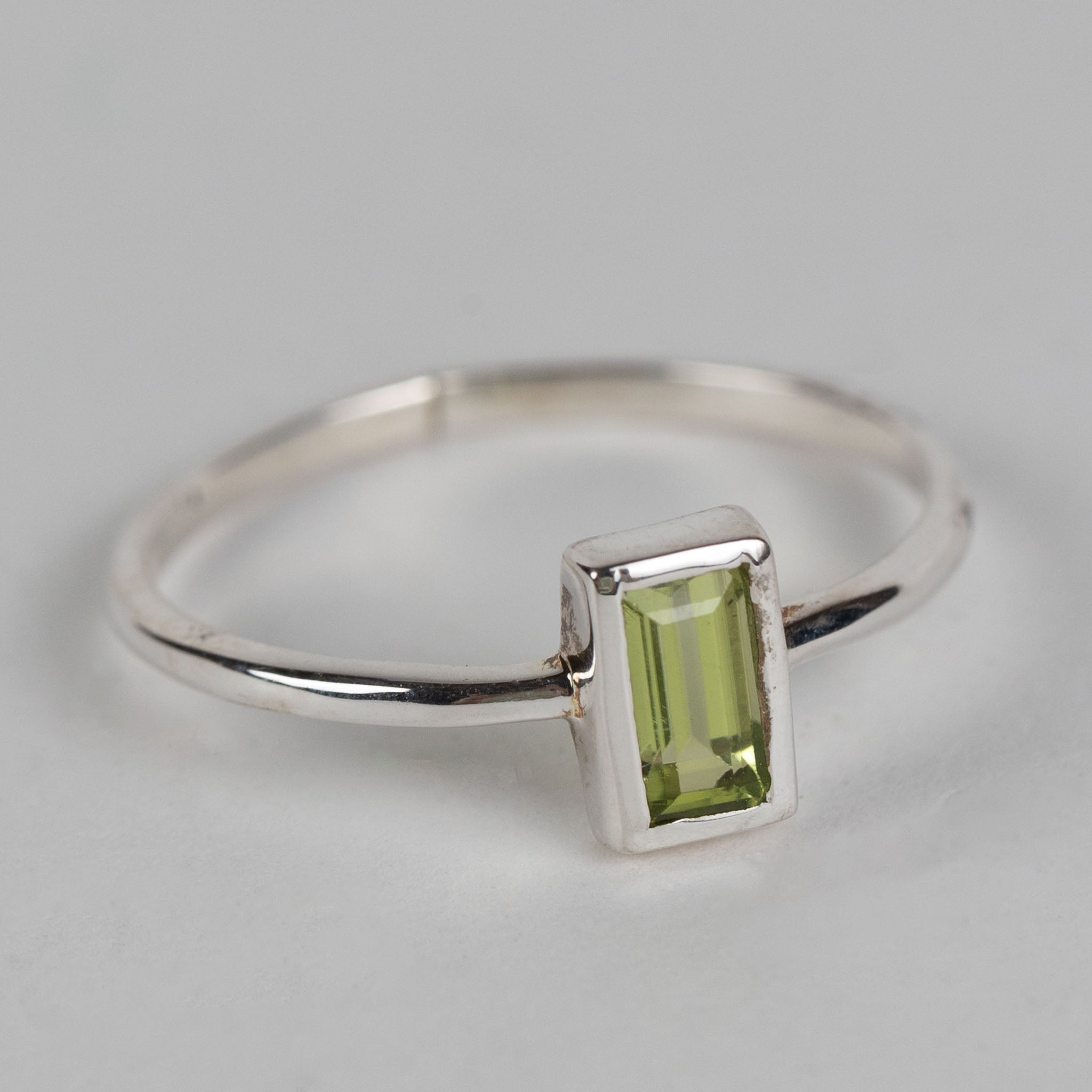 Model wearing a peridot silver ring, showcasing its elegant design