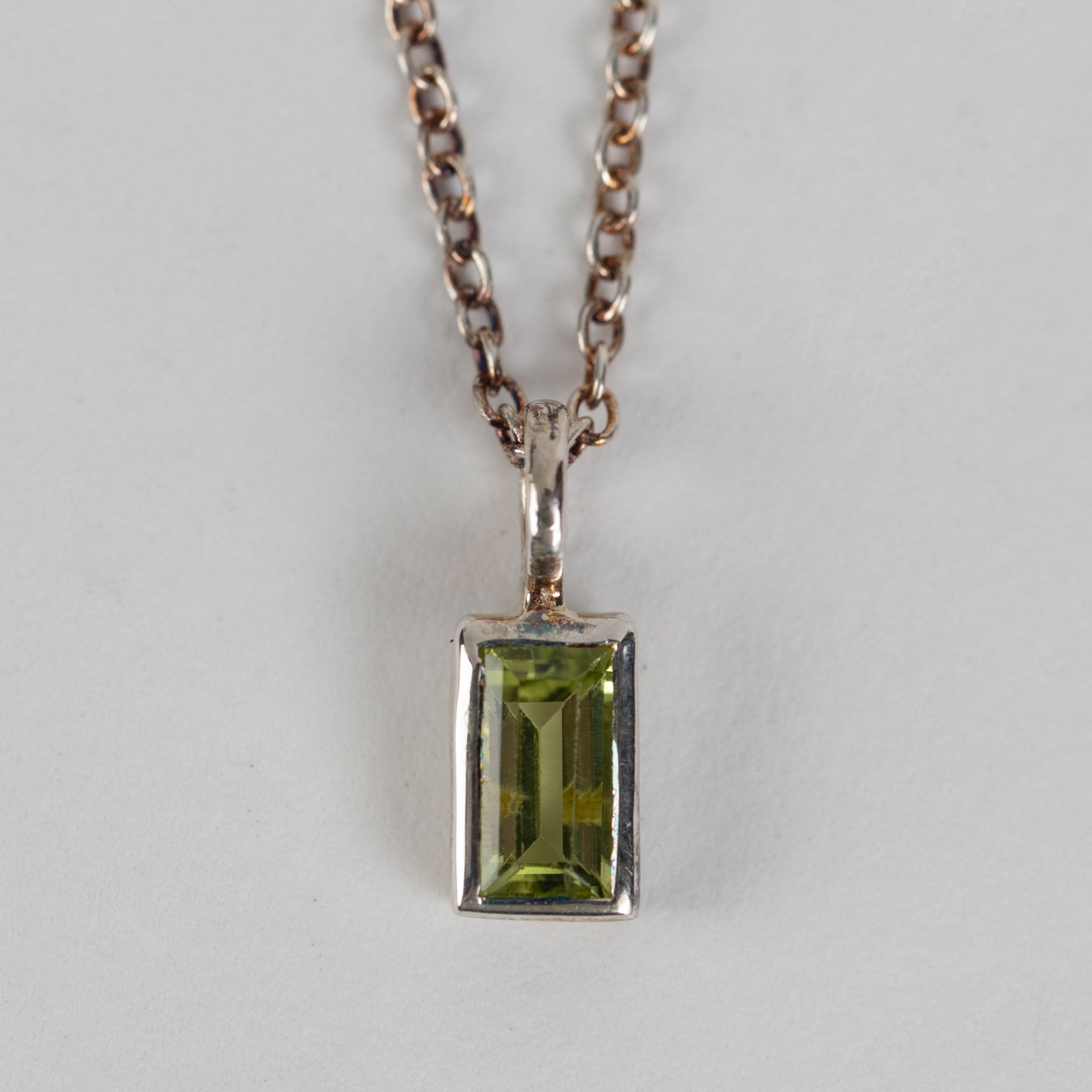 Model wearing the peridot silver pendant necklace, showcasing its elegance.