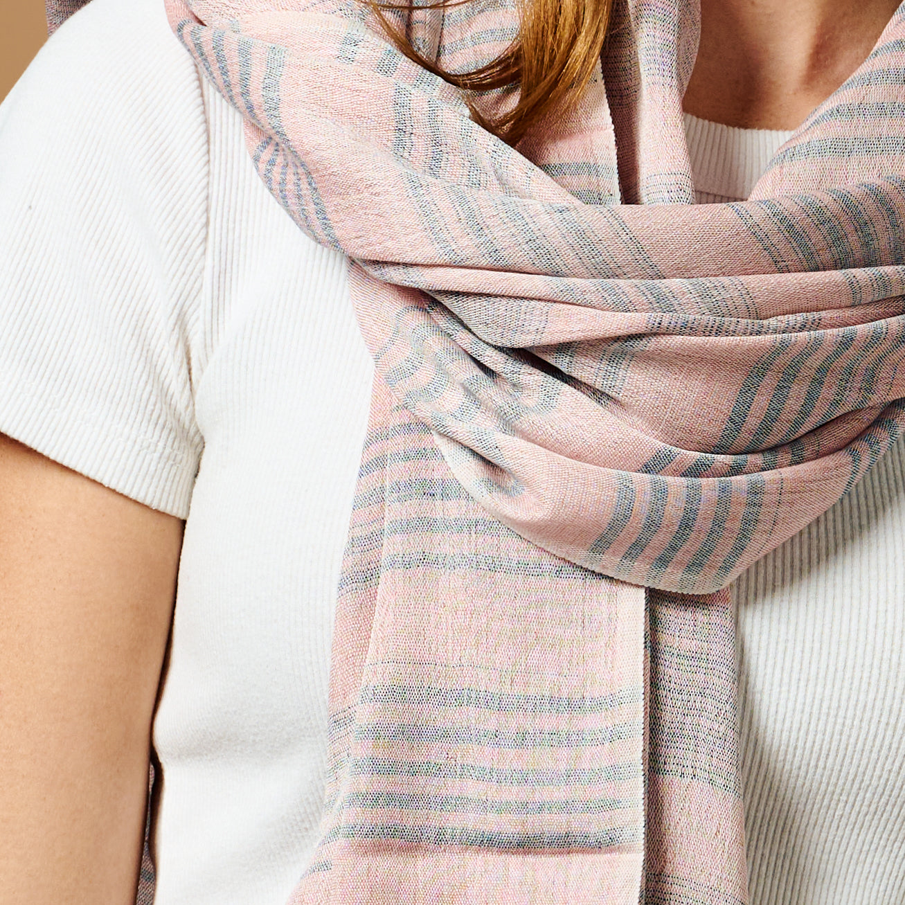 Model wearing the blush scarf styled for a spring outing, highlighting its versatility.