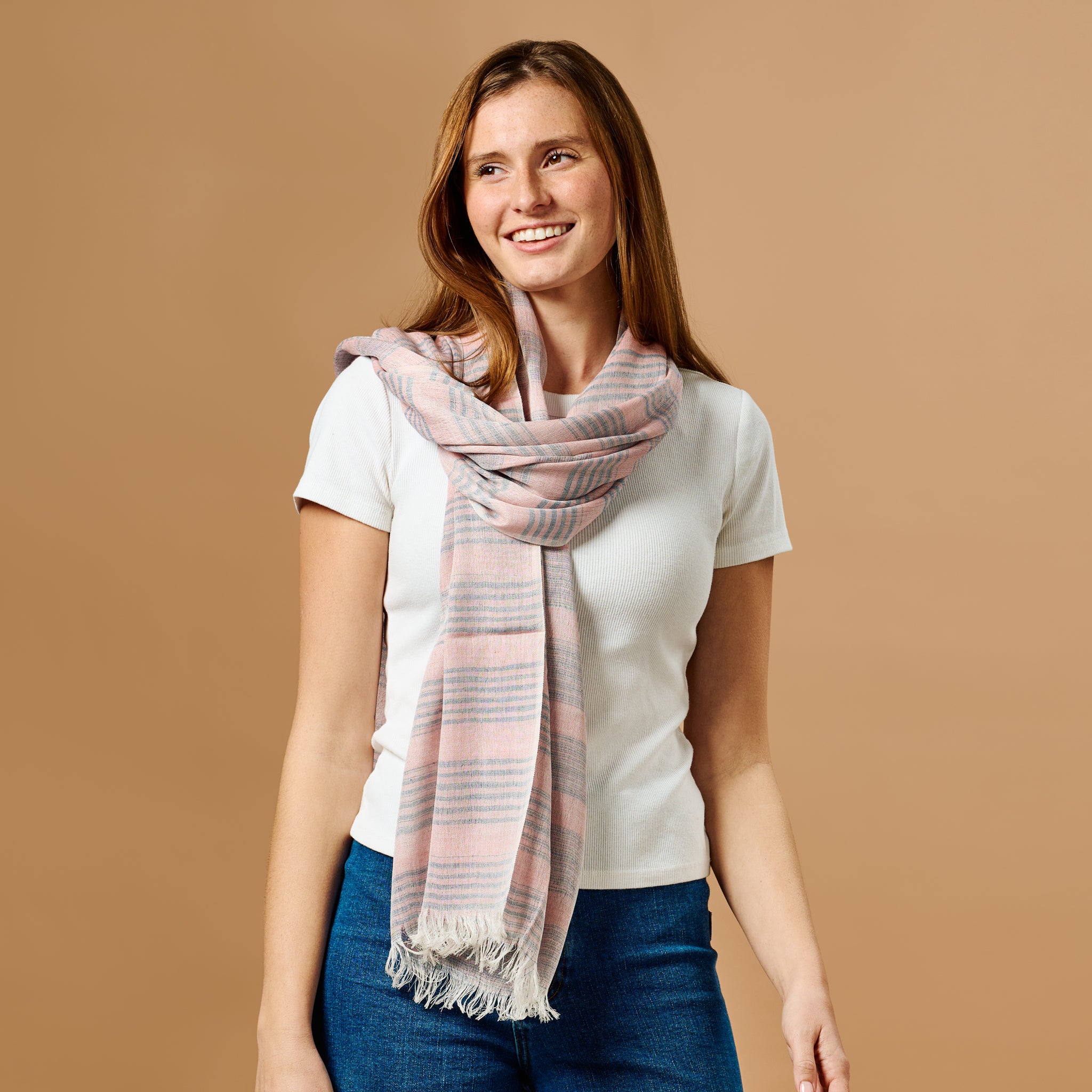 Close-up of the blush silk stripe scarf showcasing its soft texture and fringe details.