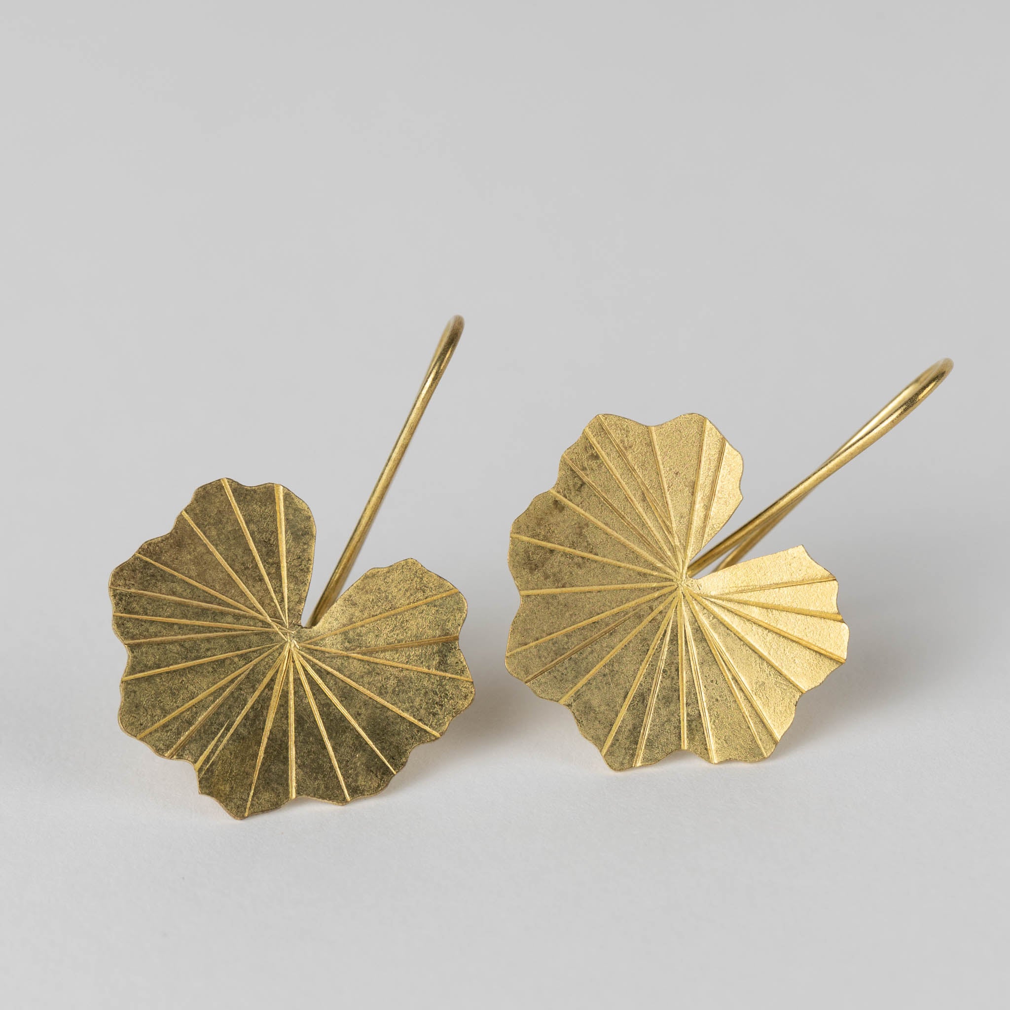 Close-up view of artisan brass lotus leaf drop earrings showcasing intricate details.