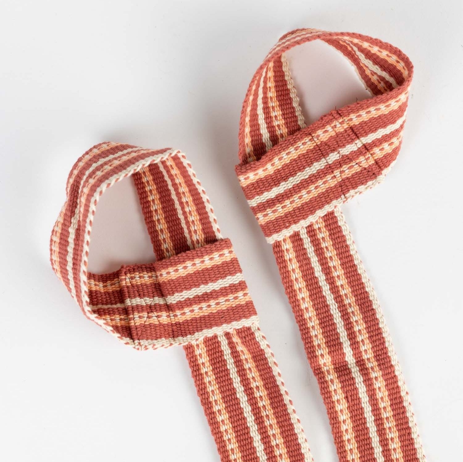 Individual using yoga strap to deepen flexibility in a yoga pose at home