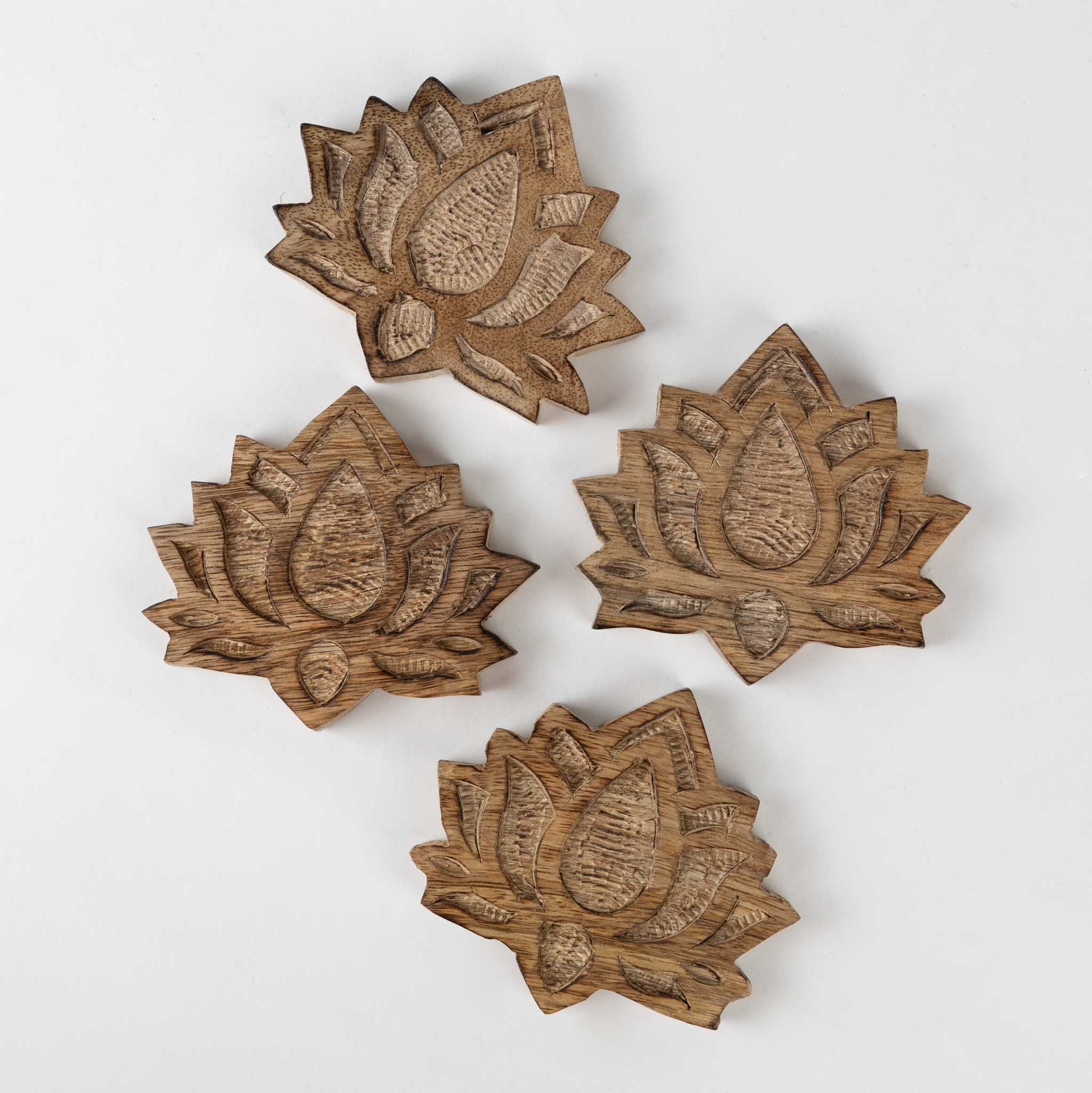 Set of four sustainable mango wood coasters on a dining table