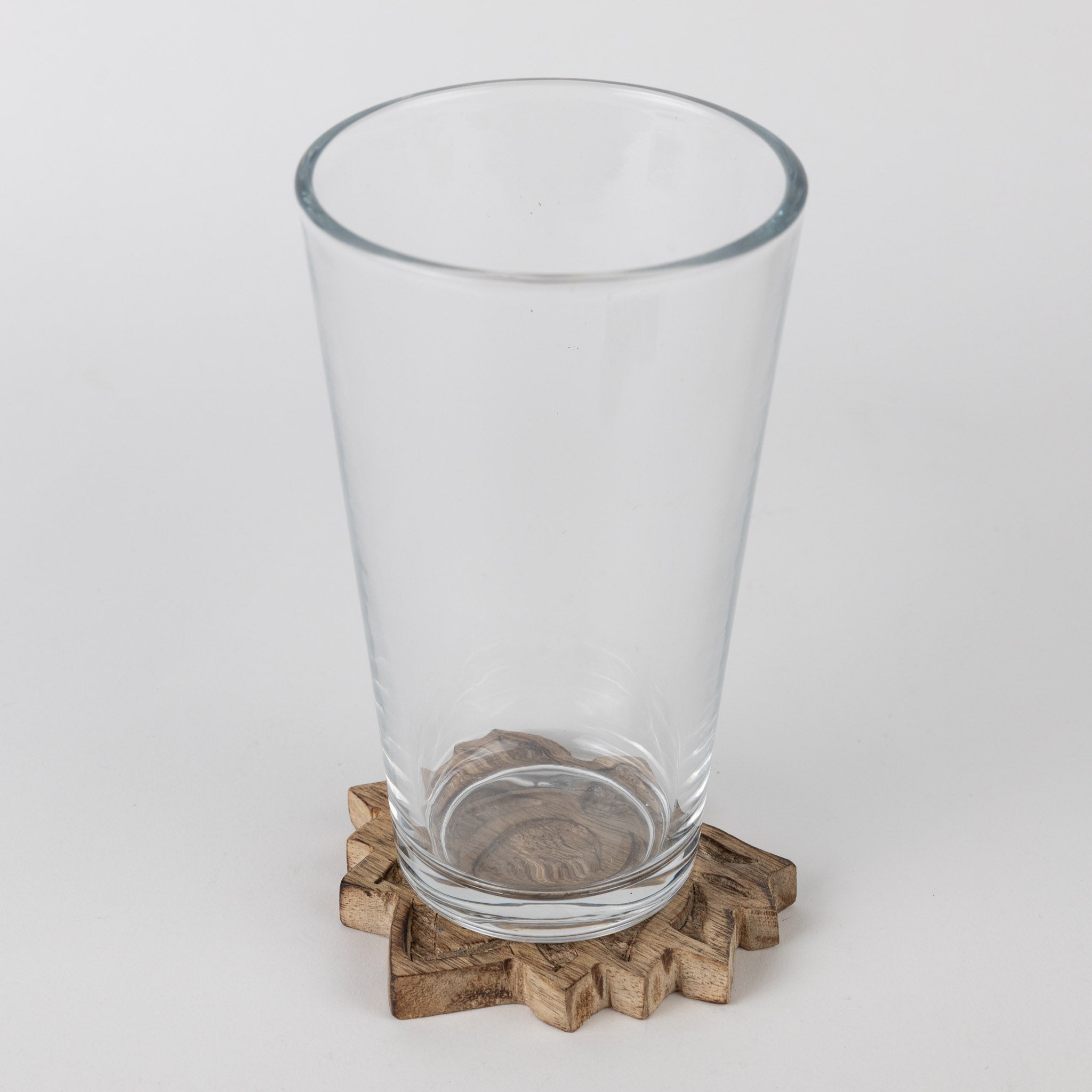 Set of four sustainable mango wood coasters on a dining table