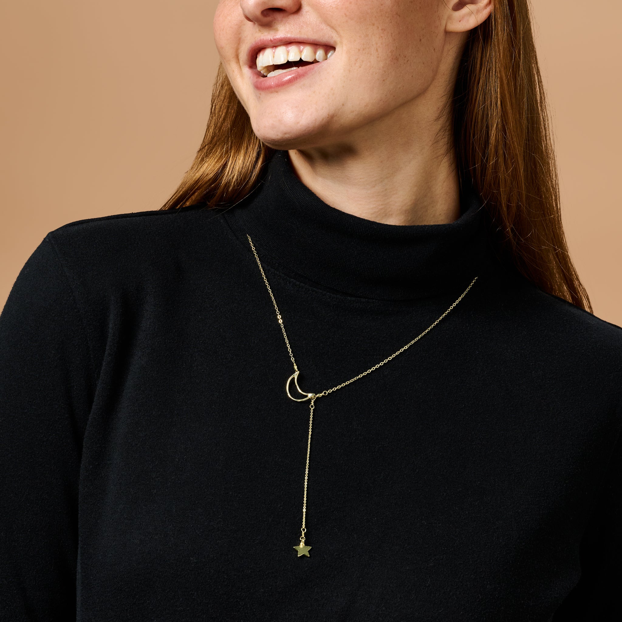 Celestial Dreamer artisan necklace displayed on a wooden surface, showcasing its intricate design.
