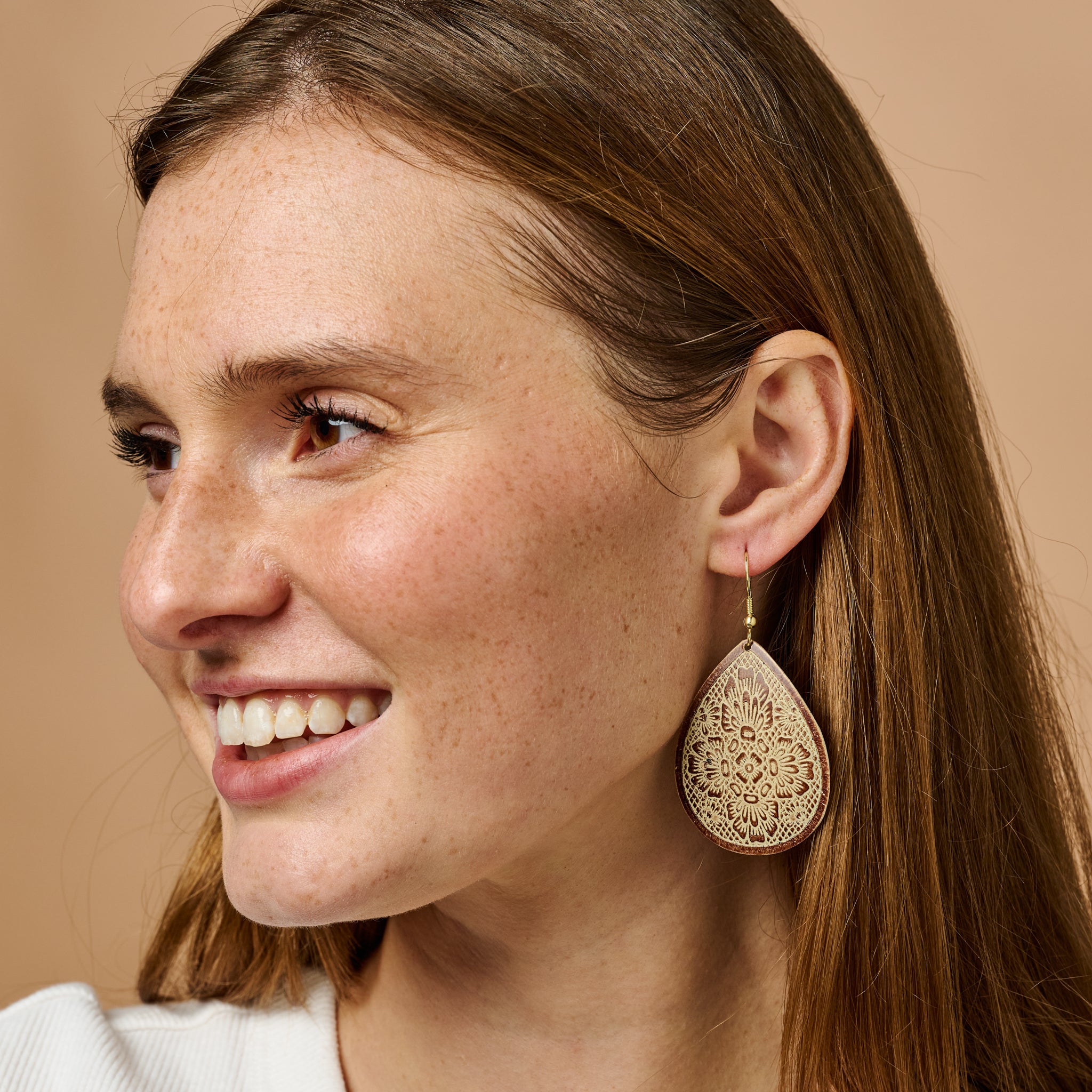 Elegant artisan teardrop earrings featuring a floral design, displayed elegantly against a soft background.