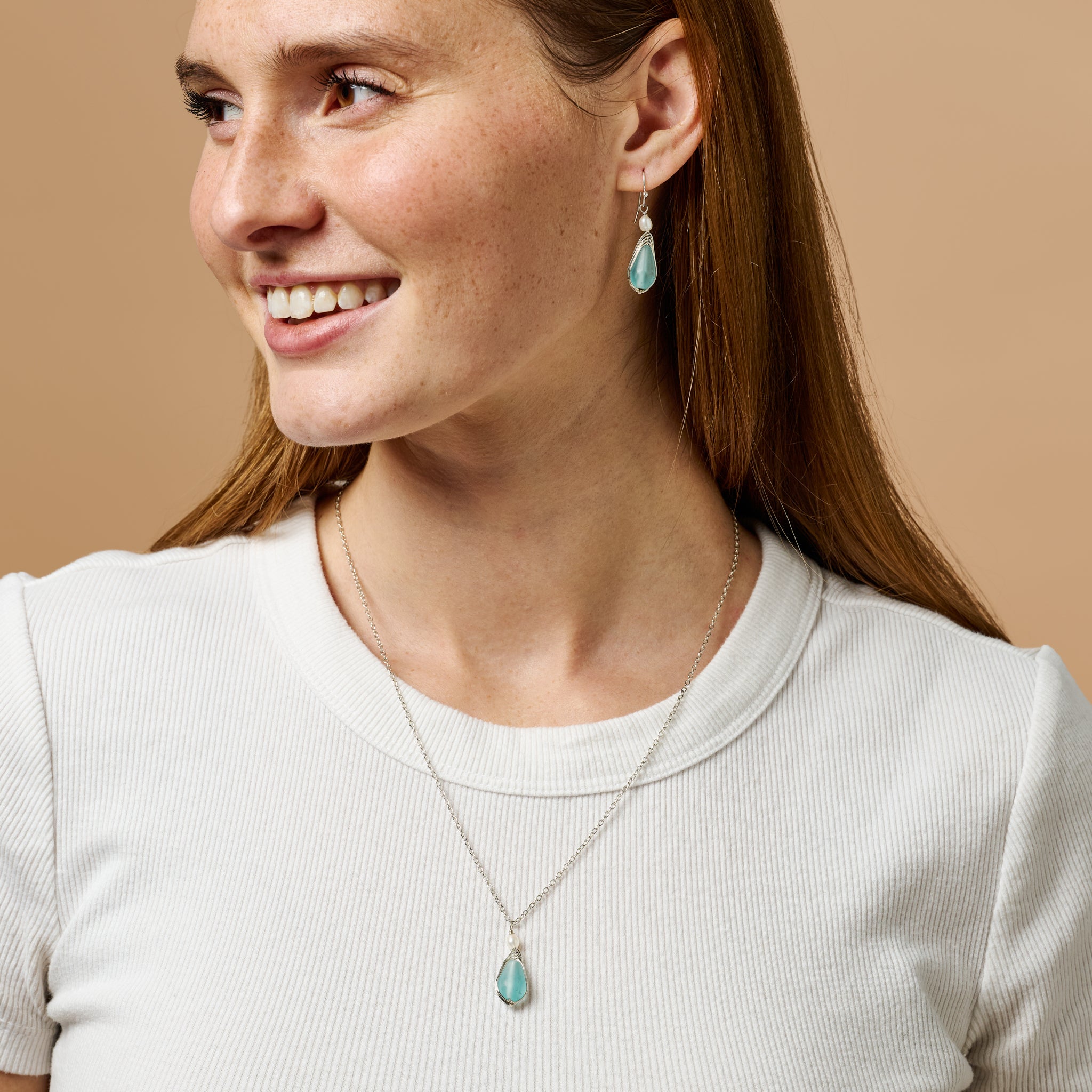 Model wearing the aqua pearl silver drop earrings, showcasing their elegant dangle style at a formal event.