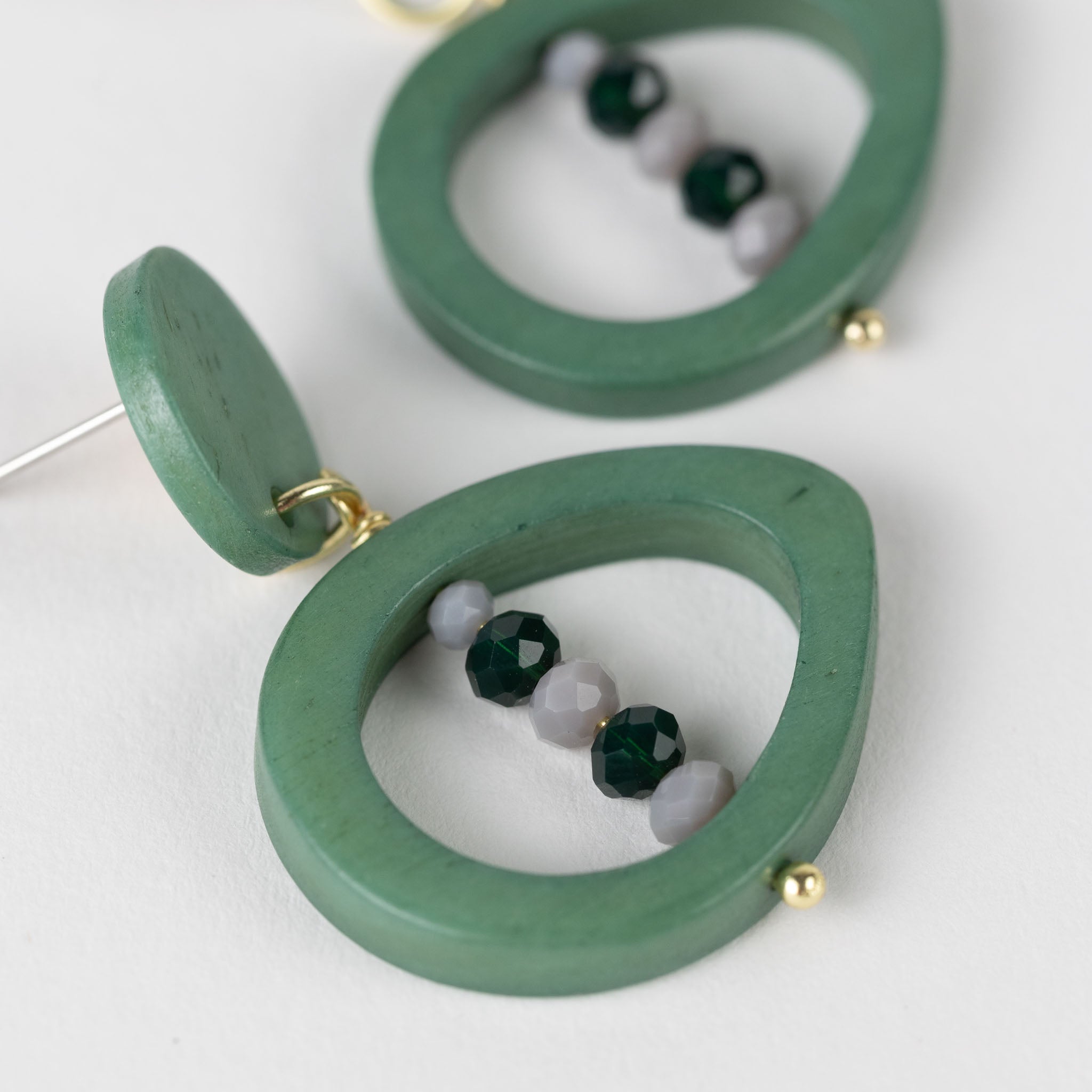 Model wearing eco-friendly handmade bone earrings with colorful glass accents