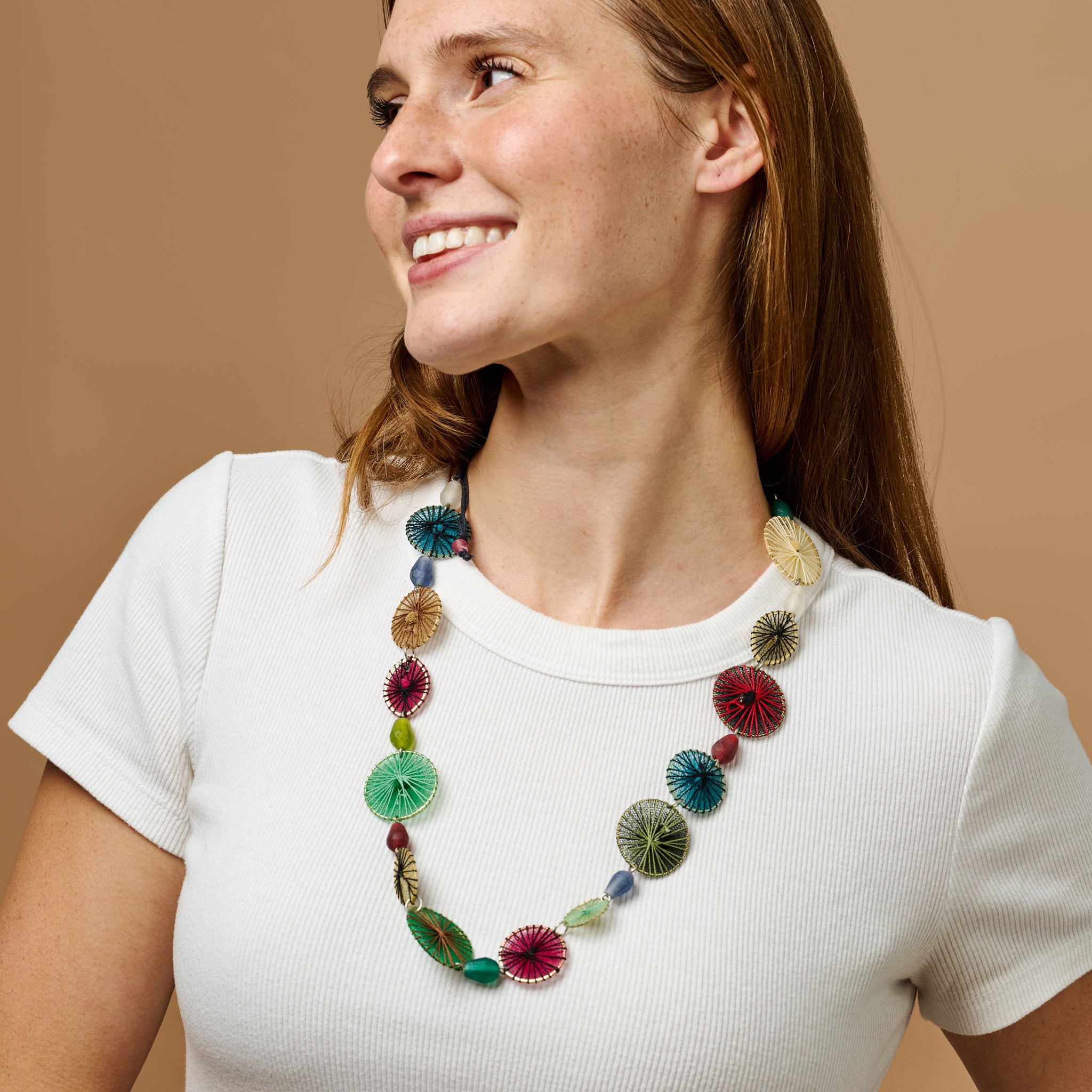 Colorful dreamcatcher necklace hanging elegantly, showcasing intricate beadwork.