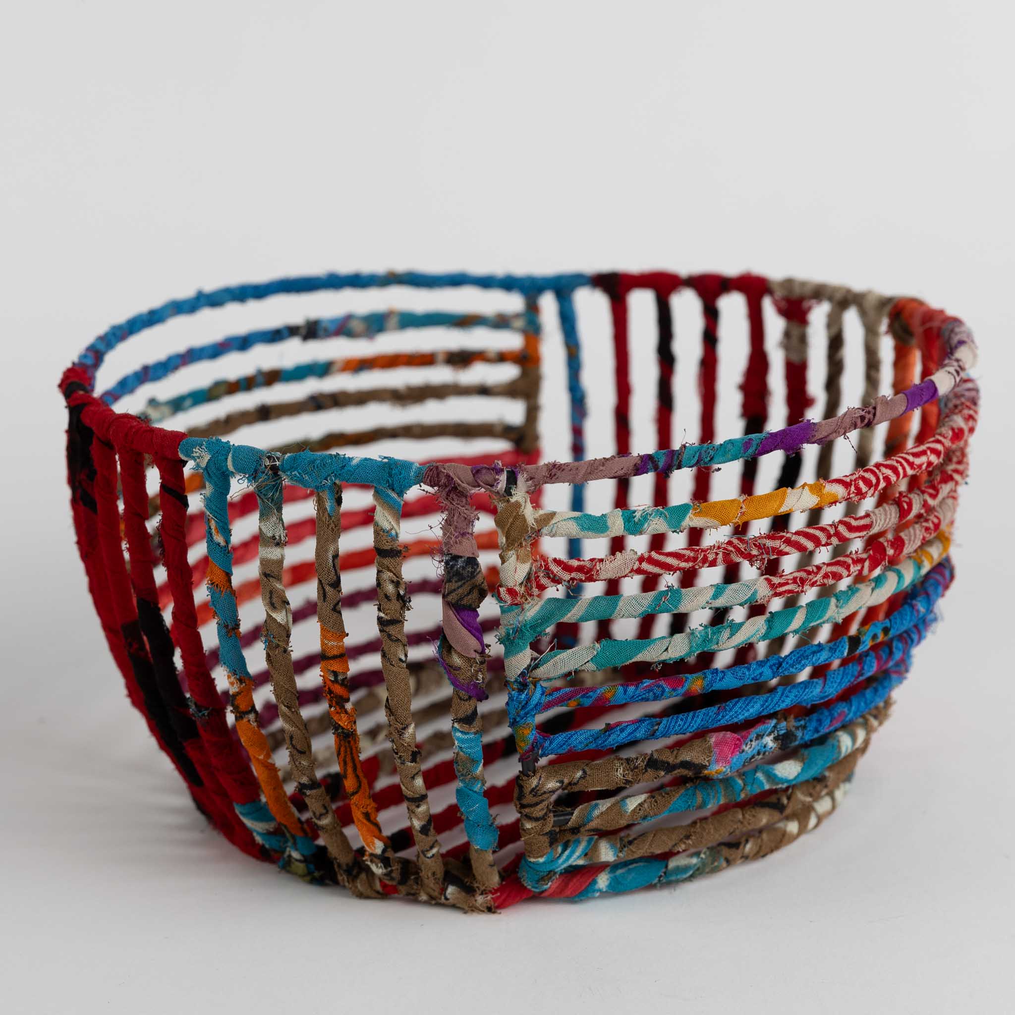 Bright sari storage basket displayed in a kitchen setting, ideal for organizing utensils.