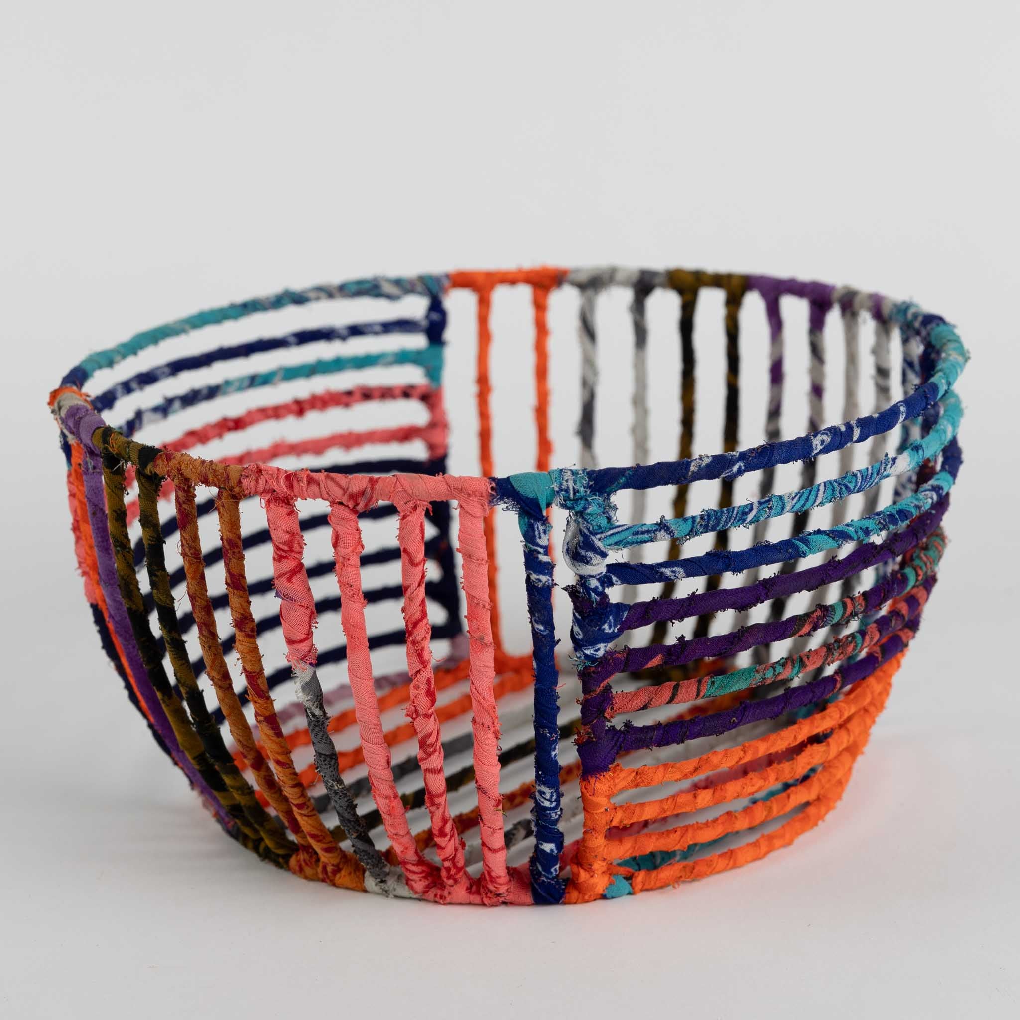 Eco-friendly wire basket for office use, showcasing colorful sari patterns.