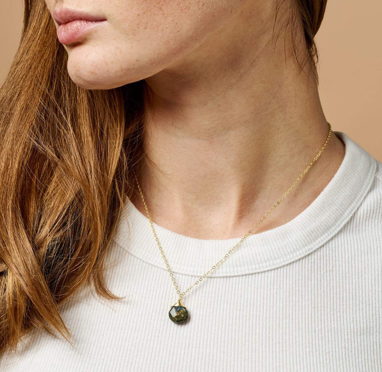 Close-up of handcrafted labradorite necklace with gold wire wrapping