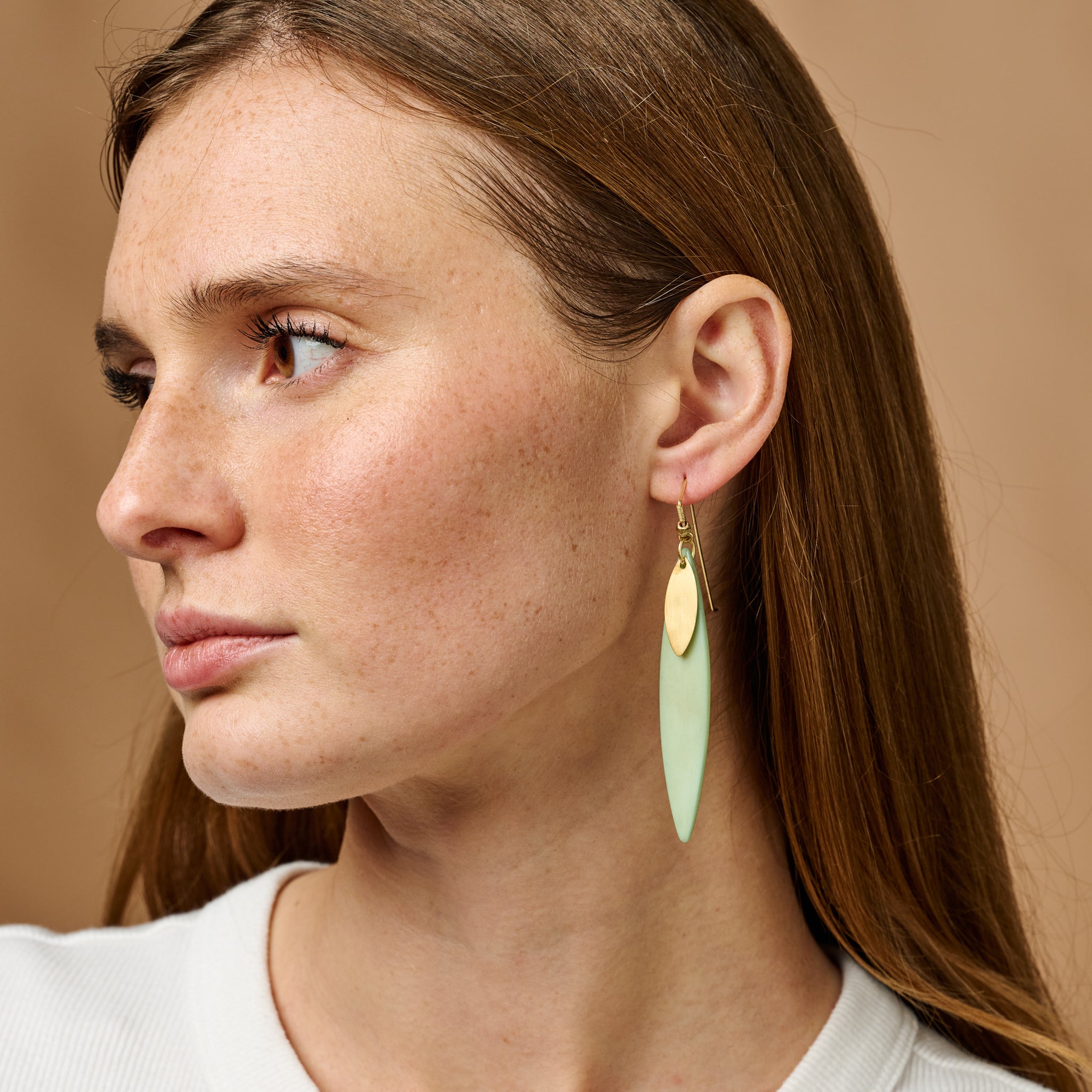 Eco-chic green artisan earrings showcasing a vibrant green hue and metallic finish from an angle.