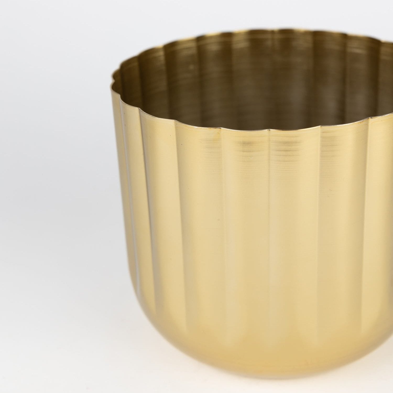 Close-up of handcrafted brass planter with scalloped edges for home decor