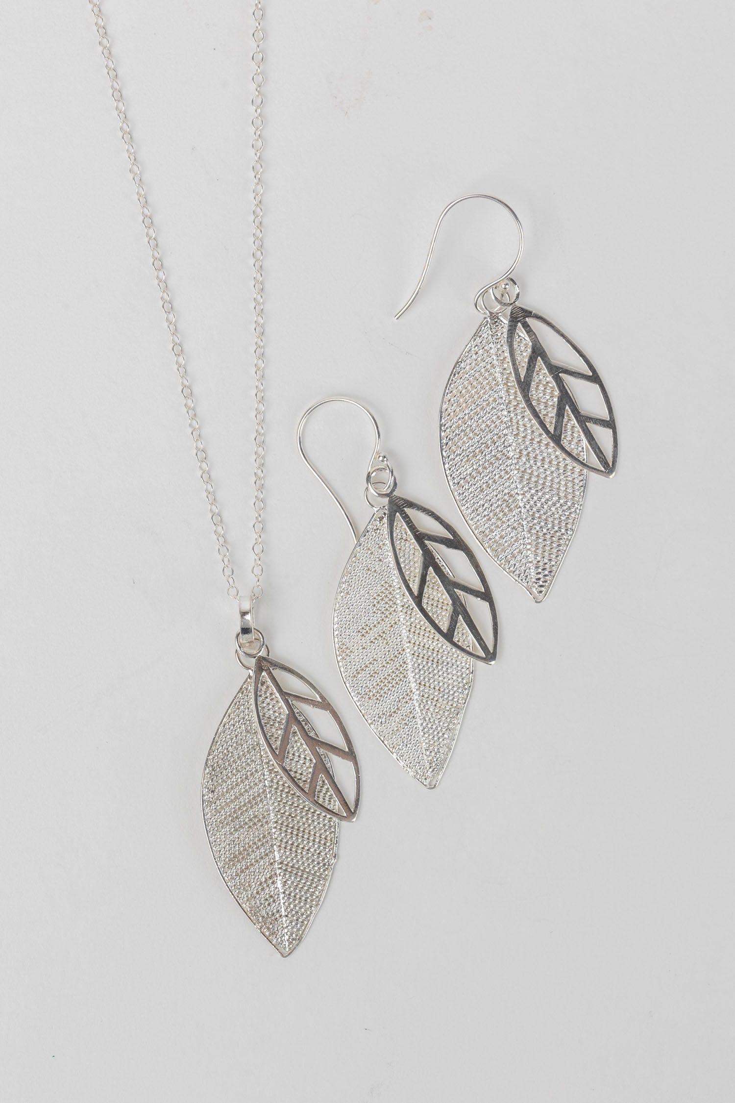 Close-up of artisan silver leaf earrings highlighting the filigree detail.