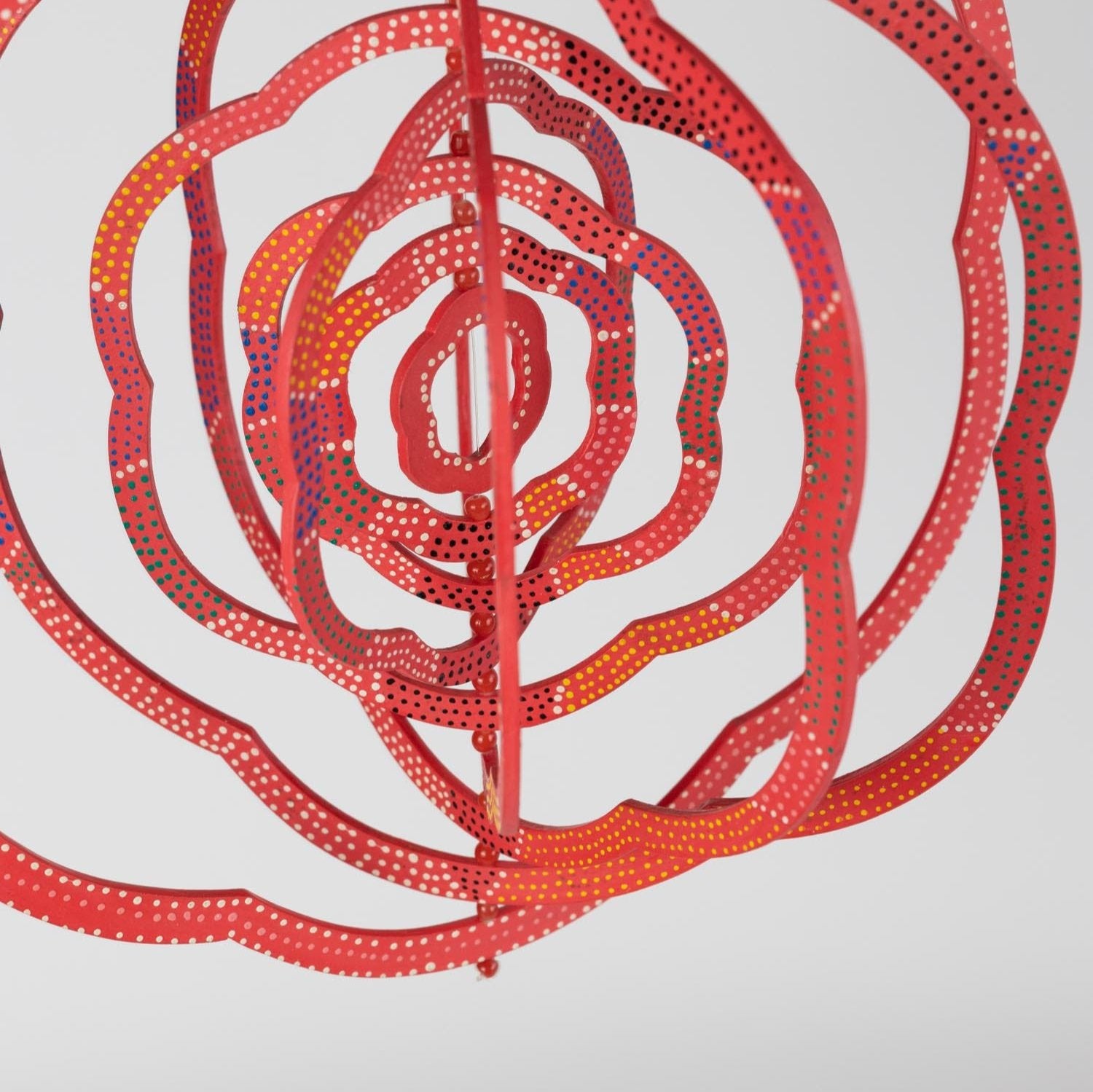 Artisan carefully crafting a glass bead wind spinner, highlighting the ethical production process.