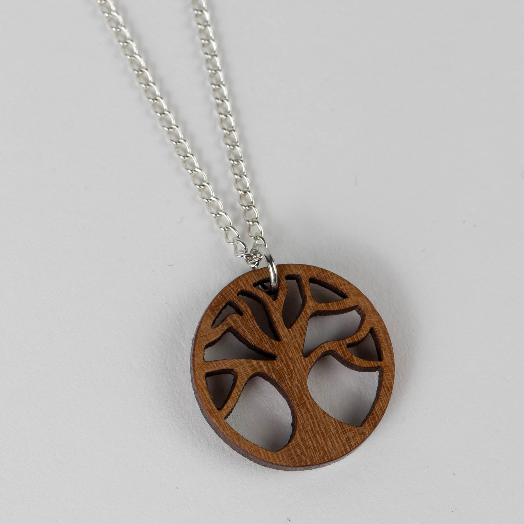 Handcrafted tree of life pendant necklace showcasing intricate wood grain design.