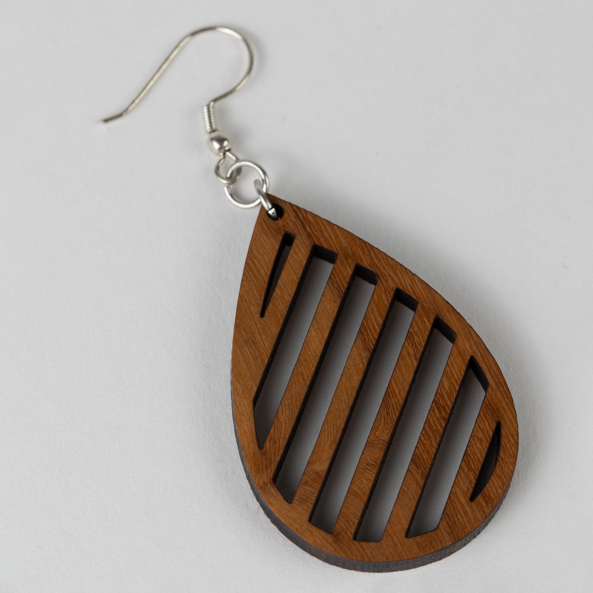 Model wearing handcrafted wooden teardrop earrings in a casual setting, showcasing their versatility.