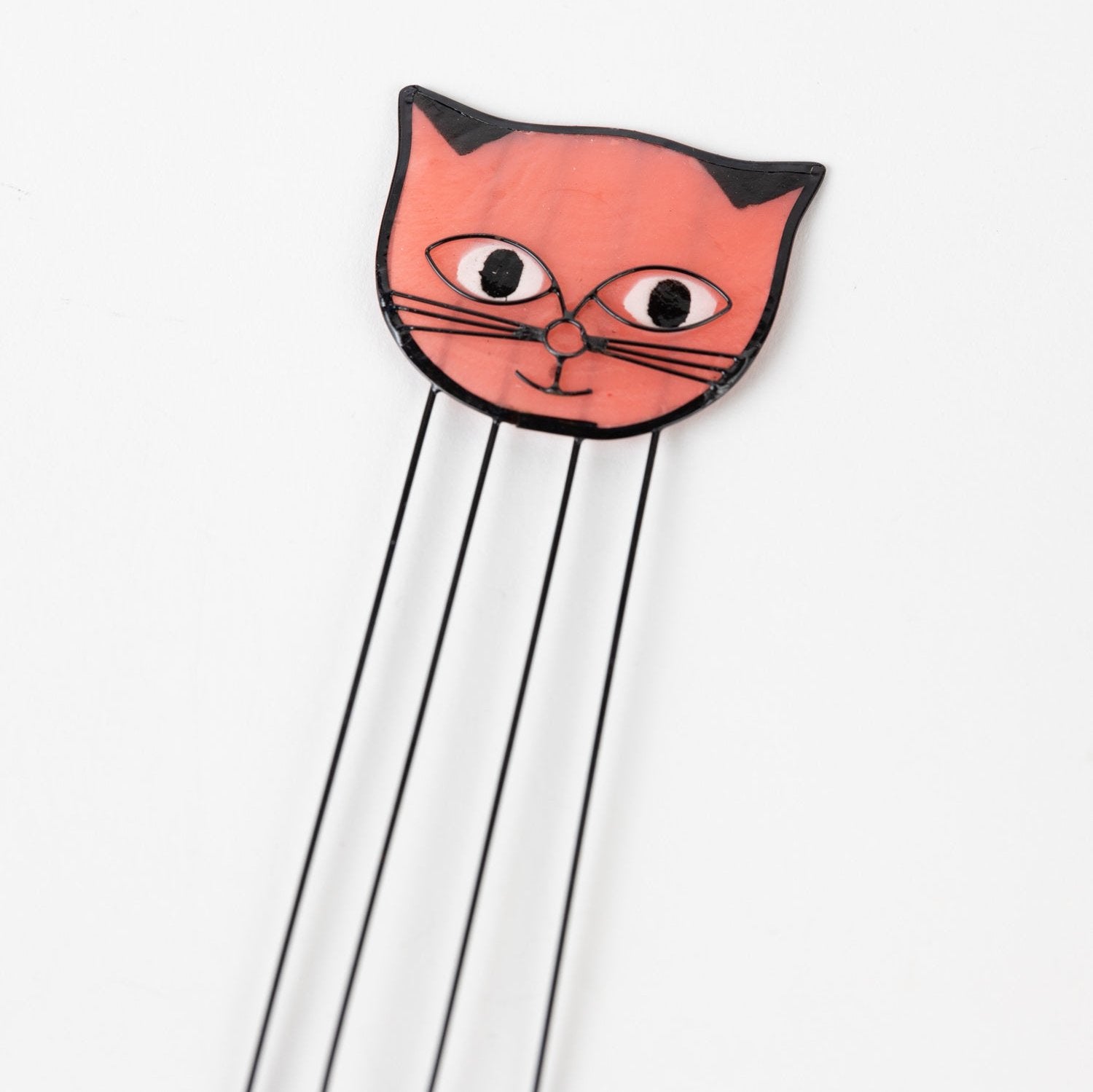 Elegant cat-themed shell bookmark resting on an open book