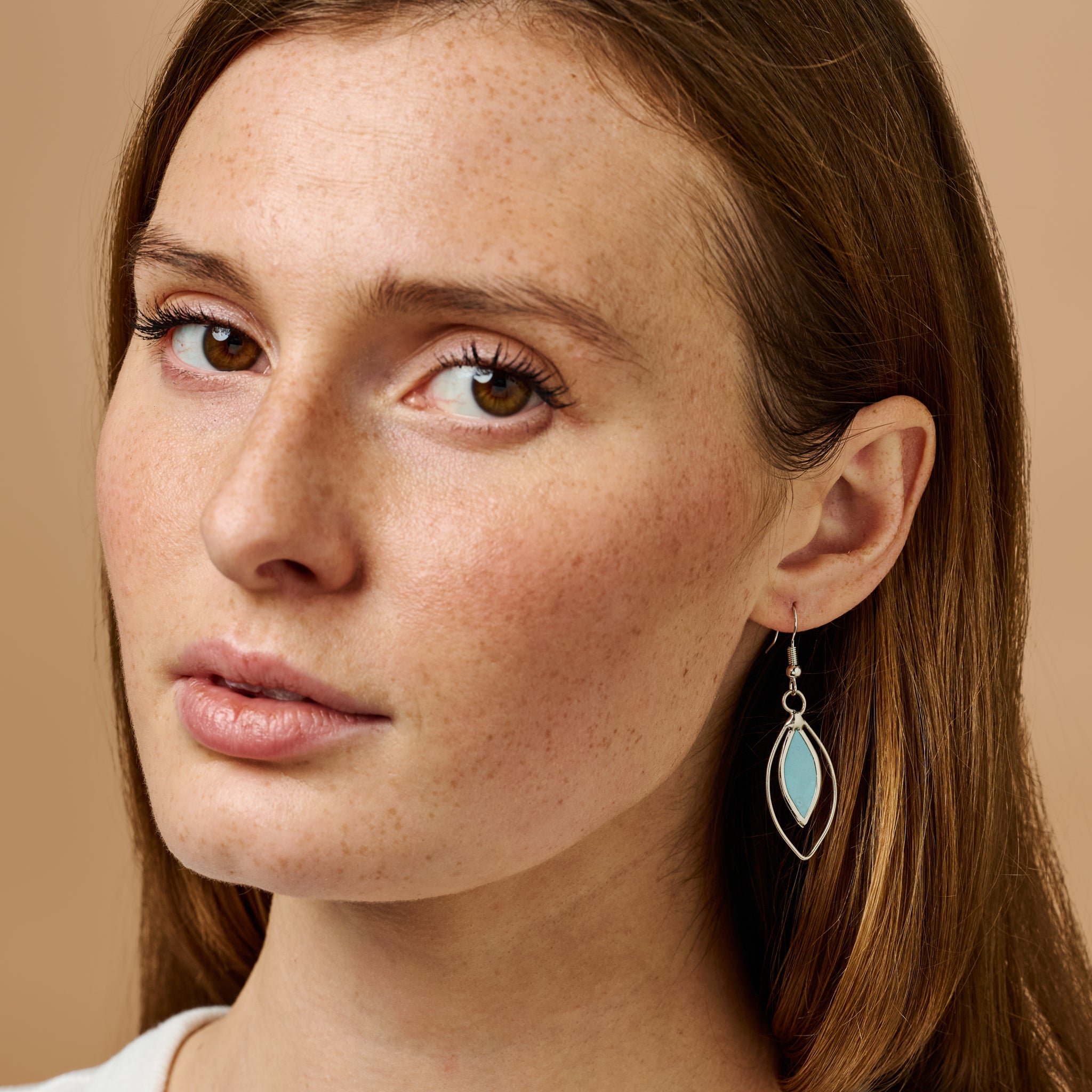 Close-up of radiant capiz shell shimmer earrings highlighting their unique design.