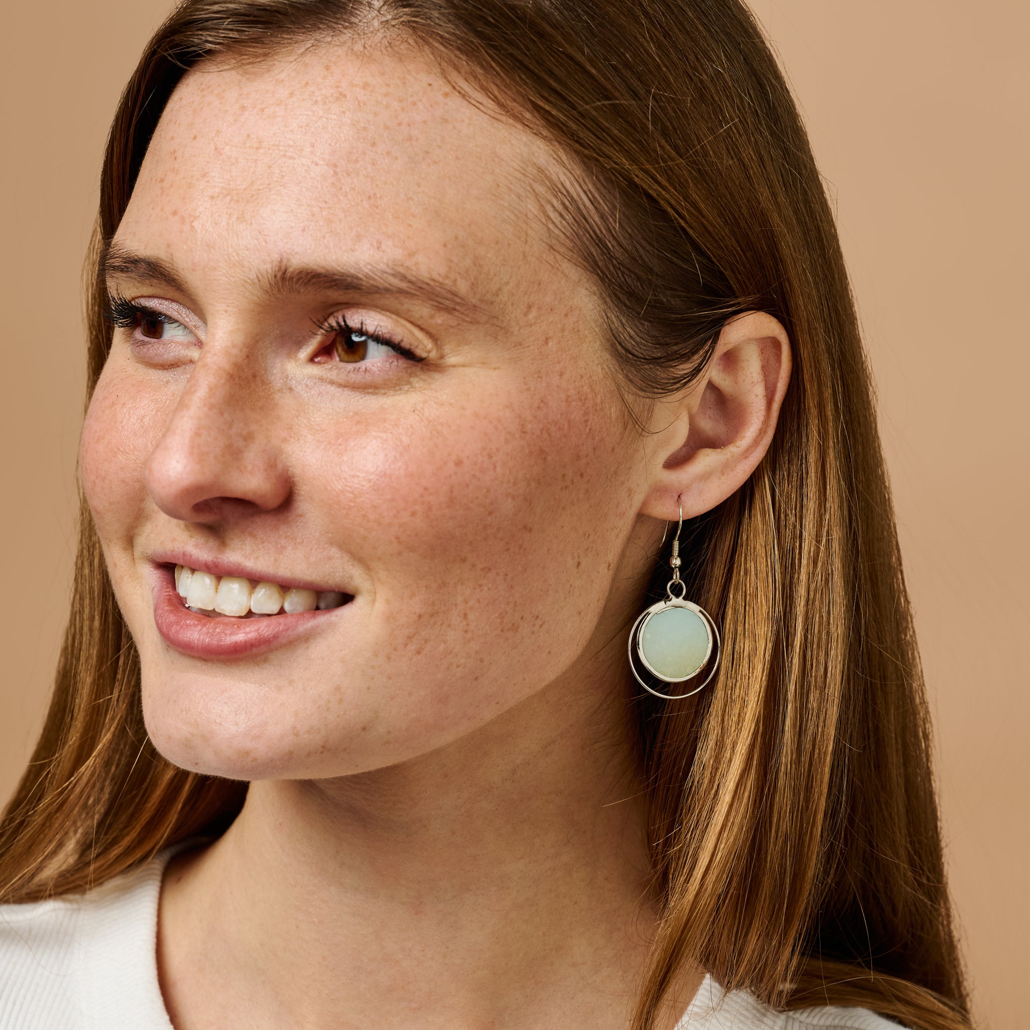 Ocean Breeze Capiz Shell Earrings in natural lighting, highlighting the sea blue color and delicate craftsmanship.