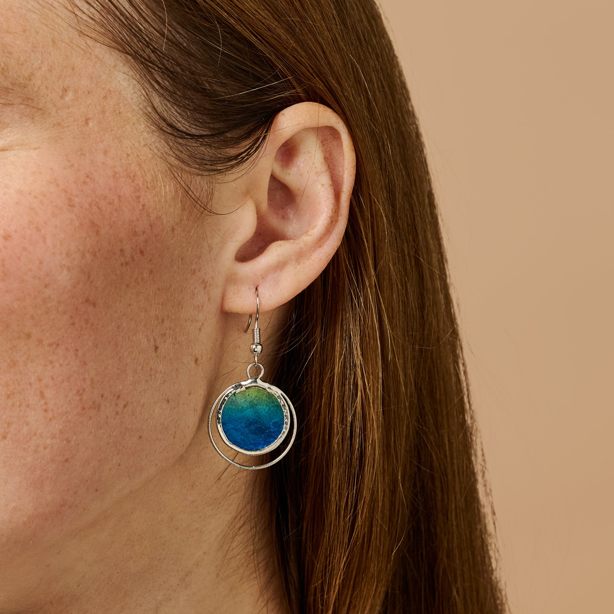 Close-up of Oceanic Echoes earrings showing capiz shell texture and metal trim
