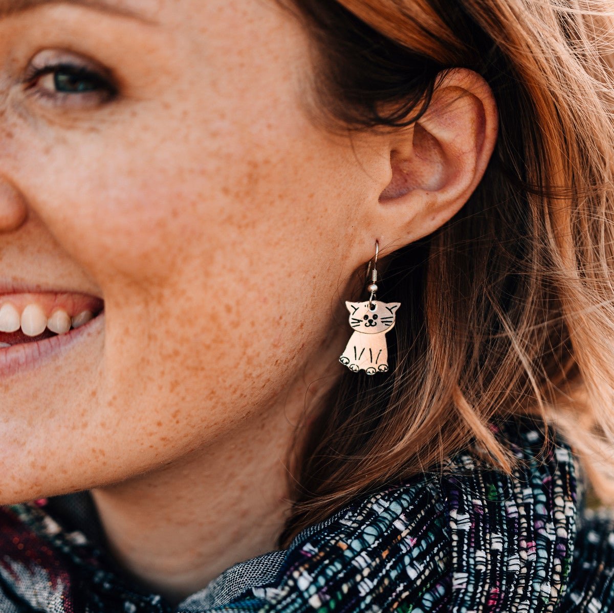 Close-up of handcrafted cat earrings showcasing intricate design and craftsmanship.