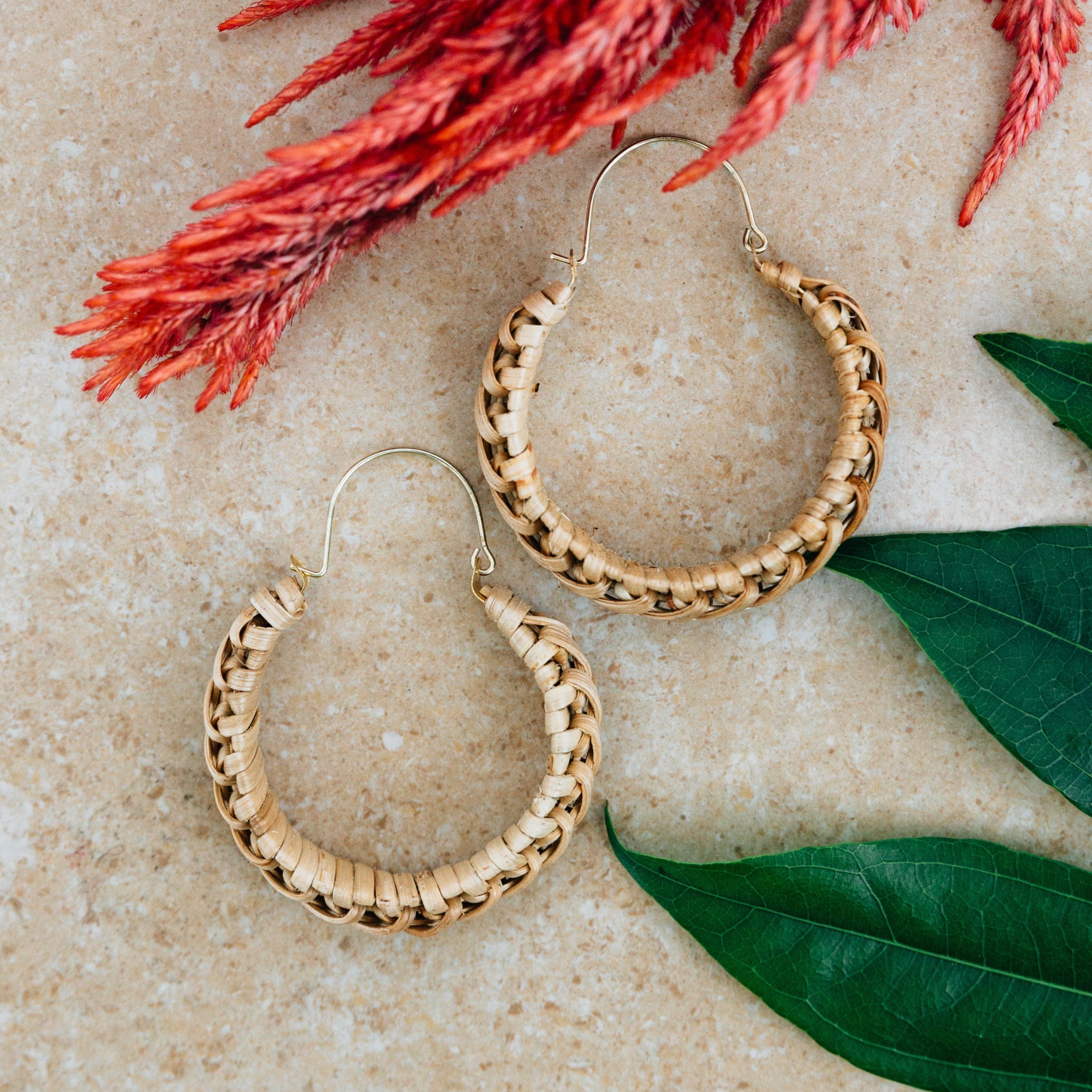 Close-up of artisan cane wrapped hoop earrings showcasing the brass wire and bamboo details.