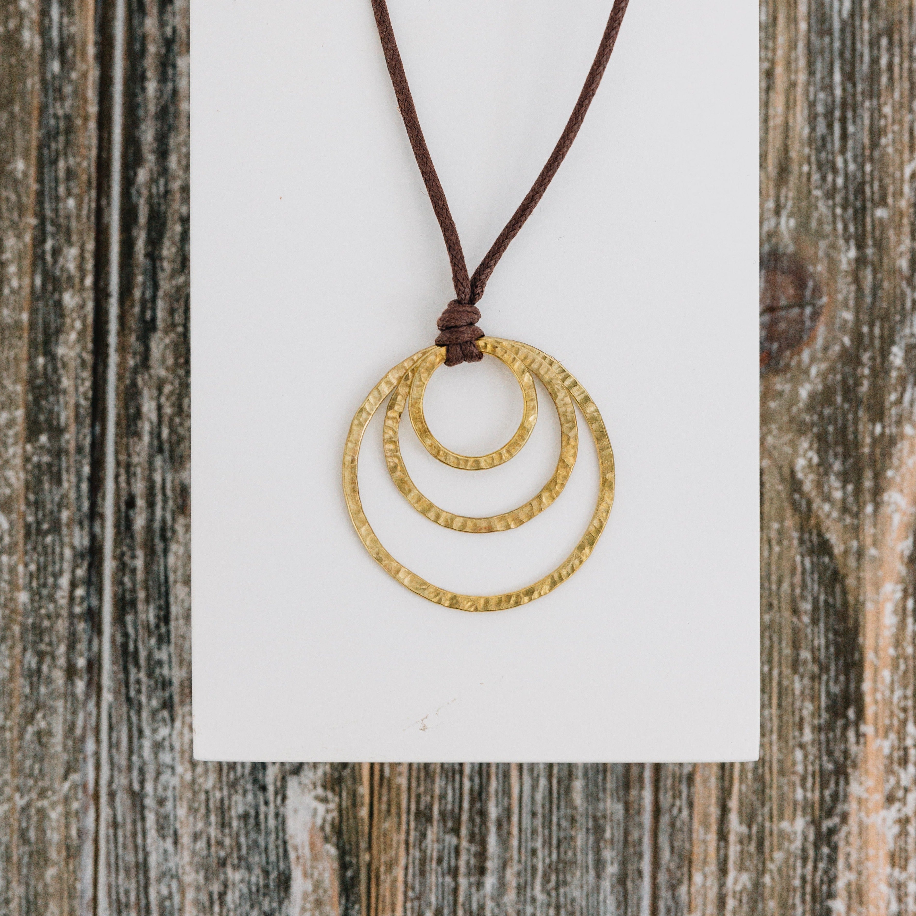 Front view of handcrafted eccentric circles necklace on display