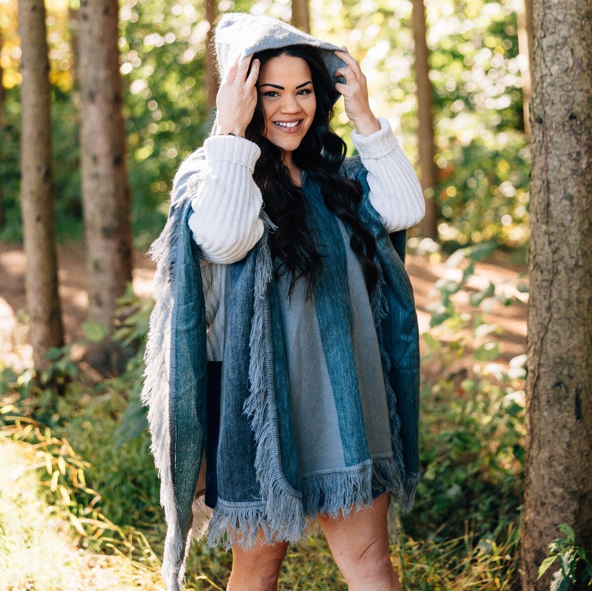 Artisan crafted winter hooded poncho draped on a rustic chair, showcasing its craftsmanship.