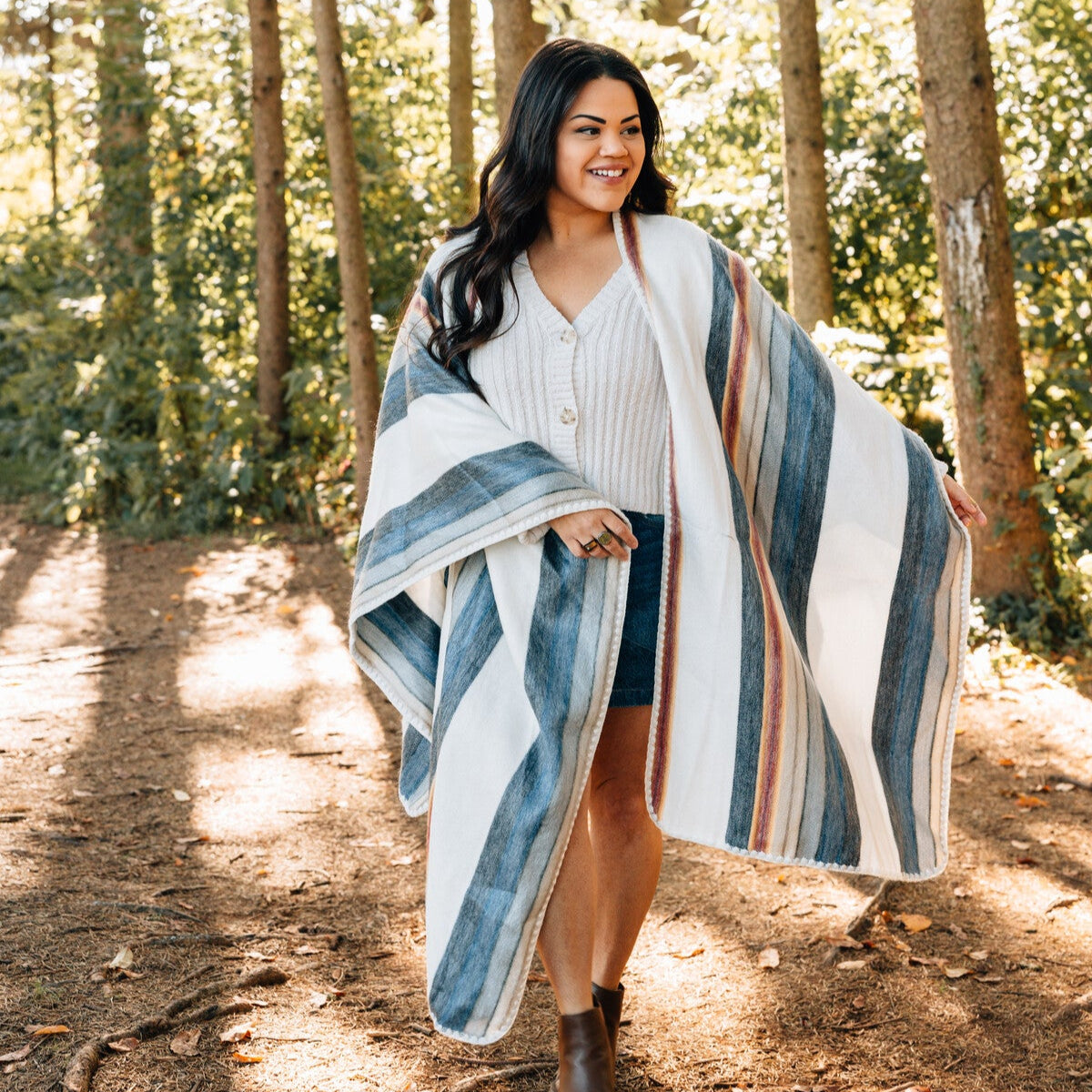 Front view of artisan reversible poncho paired with tall boots outdoors